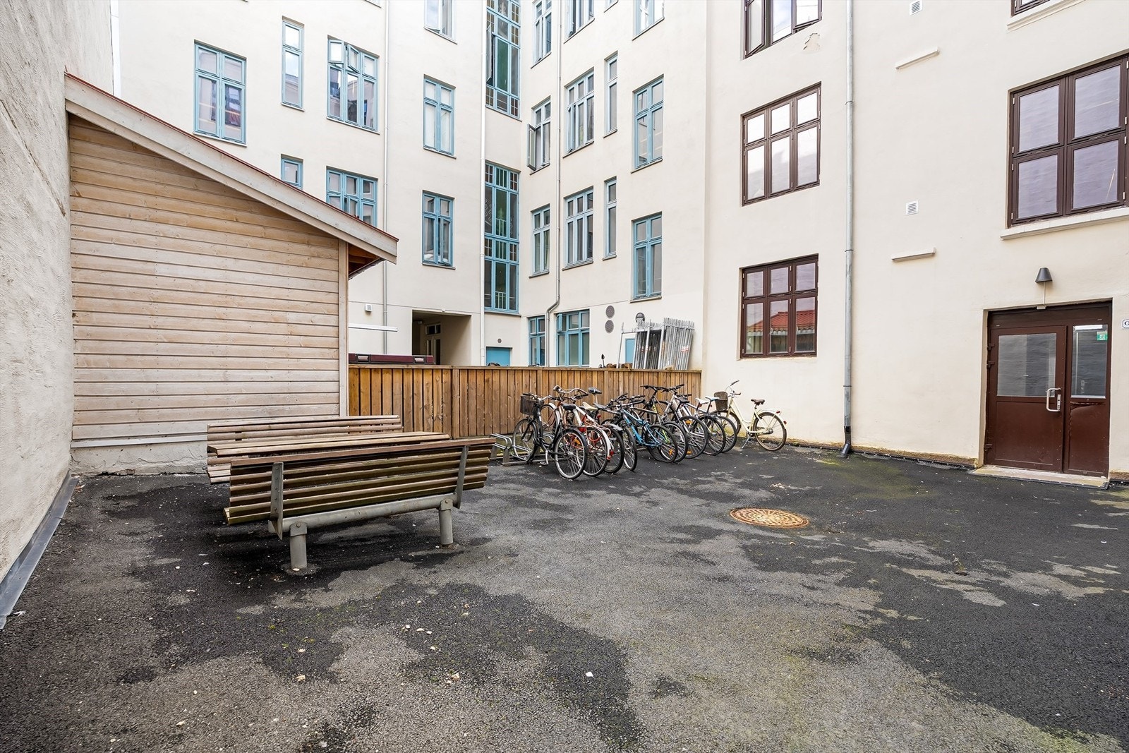 Felles bakgård for beboerne med blant annet sykkelparkering og sittergruppe. Galleribilde