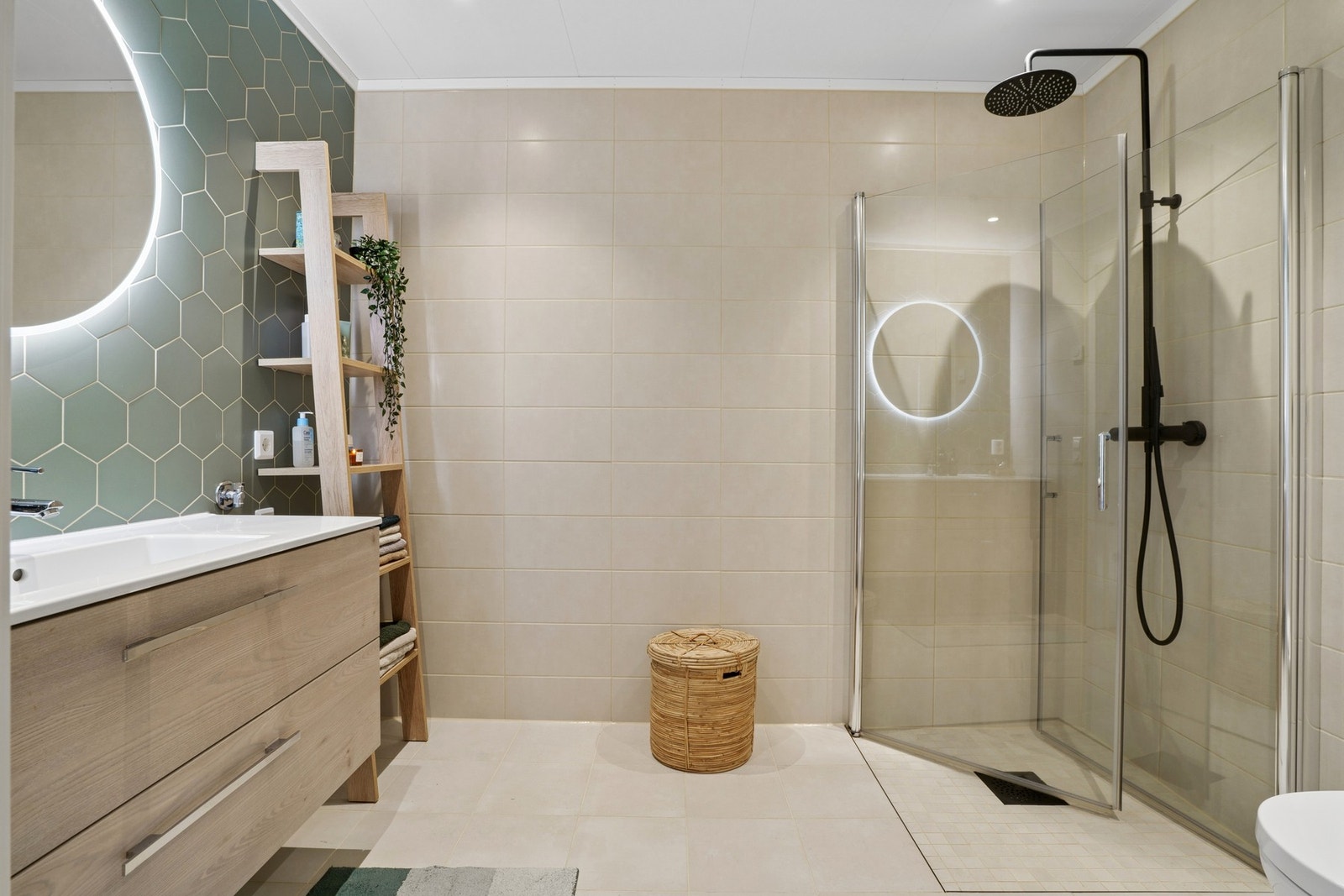 Badet er romslig, moderne og delikat innredet med flislagte overflater og en gjennomført material- og fargepalett. Galleribilde