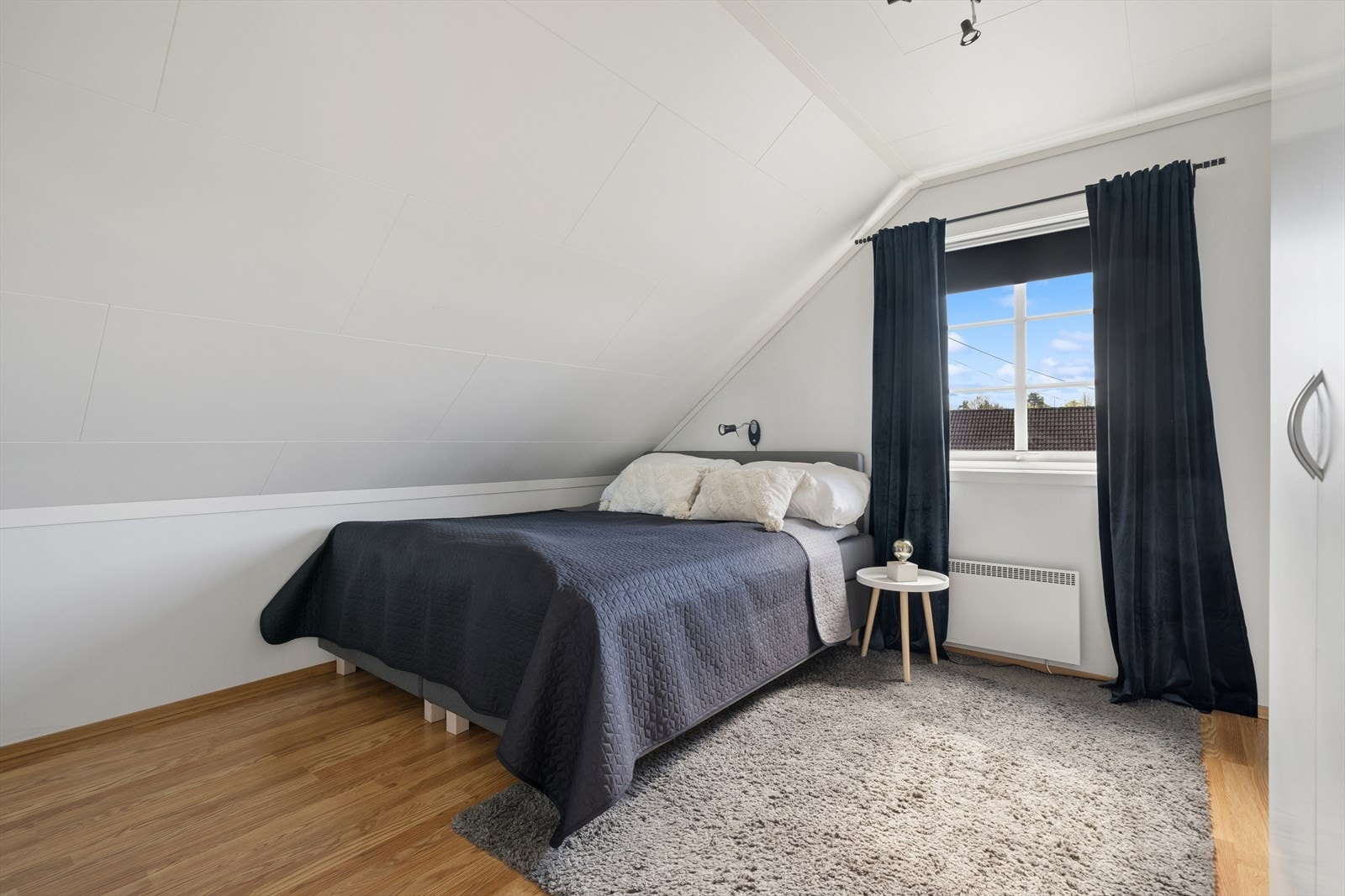 Sjarmerende og romslig soverom ll med skråtak som gir en lun og hyggelig atmosfære. Rommet har gode lysforhold fra vinduet, spennende layout, samt plass til seng og tilhørende møblement. Galleribilde