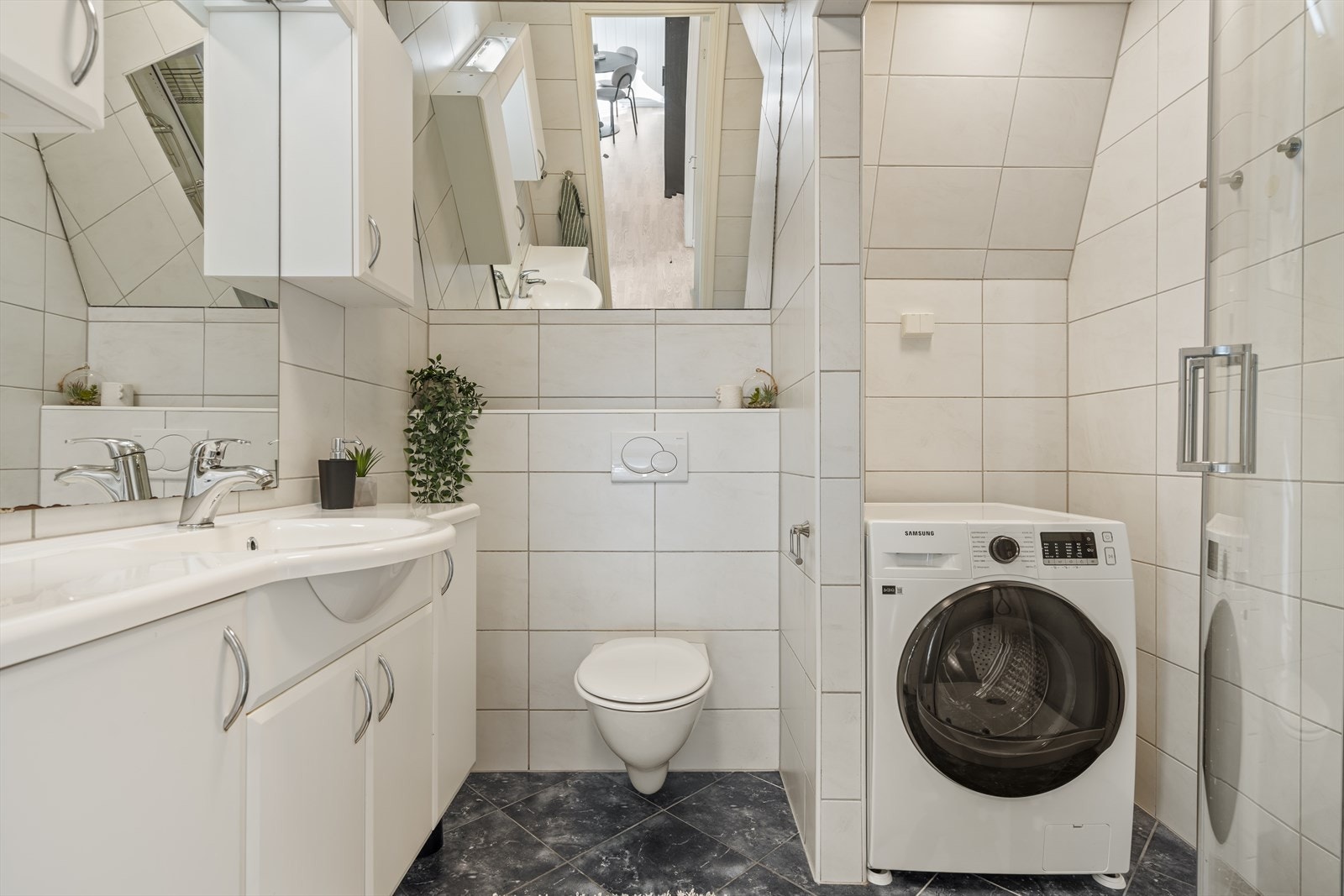 Badet i 2. etasje har flislagte overflater, dusjkabinett og opplegg for vaskemaskin. Galleribilde