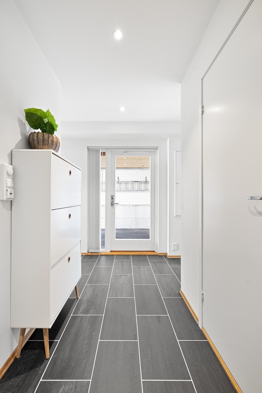 Lys og innbydende entré med flis på gulv. Galleribilde