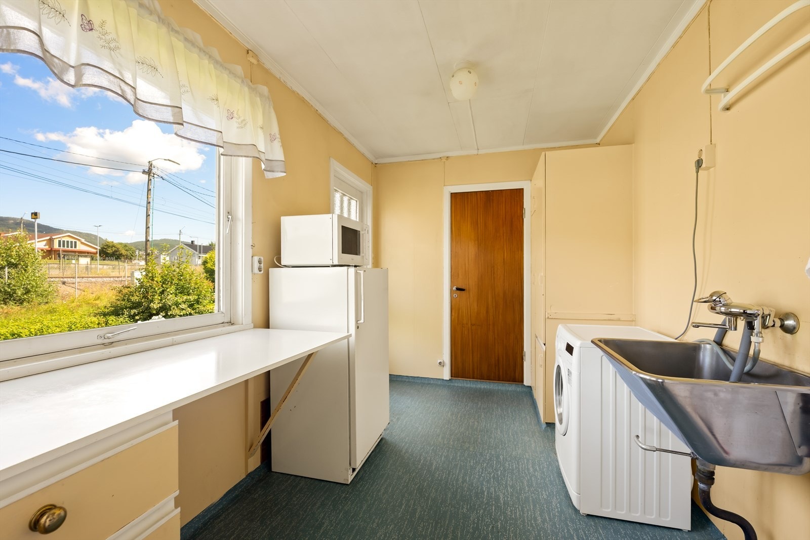 Rommet er utstyrt med skyllekar i stål og har opplegg for vaskemaskin. Galleribilde