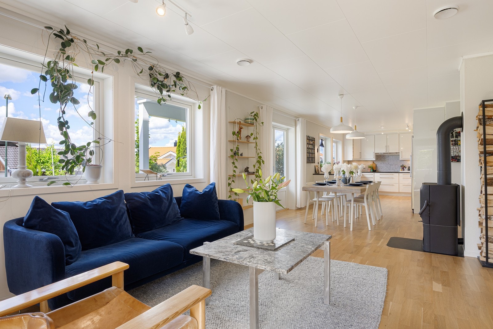 Sentralt i rommet står en moderne peisovn som sørger for ekstra hygge og varme, i tillegg er det i den innerste delen en varmepumpe fra 2025. Galleribilde
