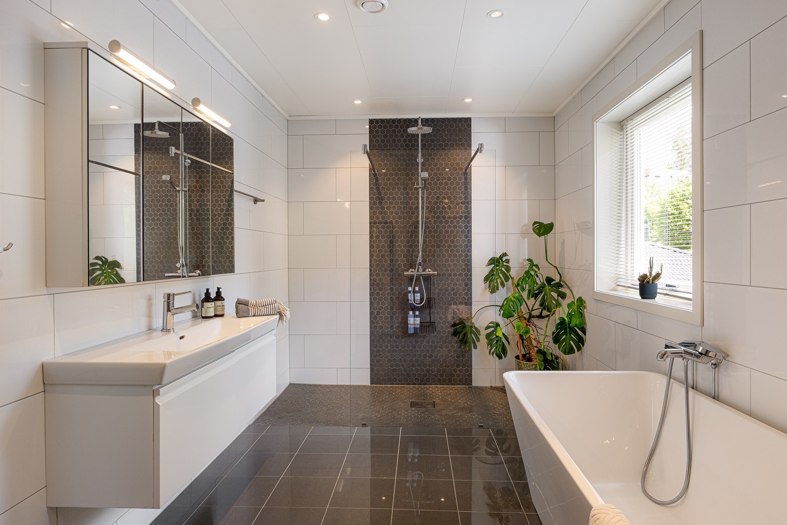 Det romslige badet har både badekar og dusjsone med regnfallsdusj. Galleribilde