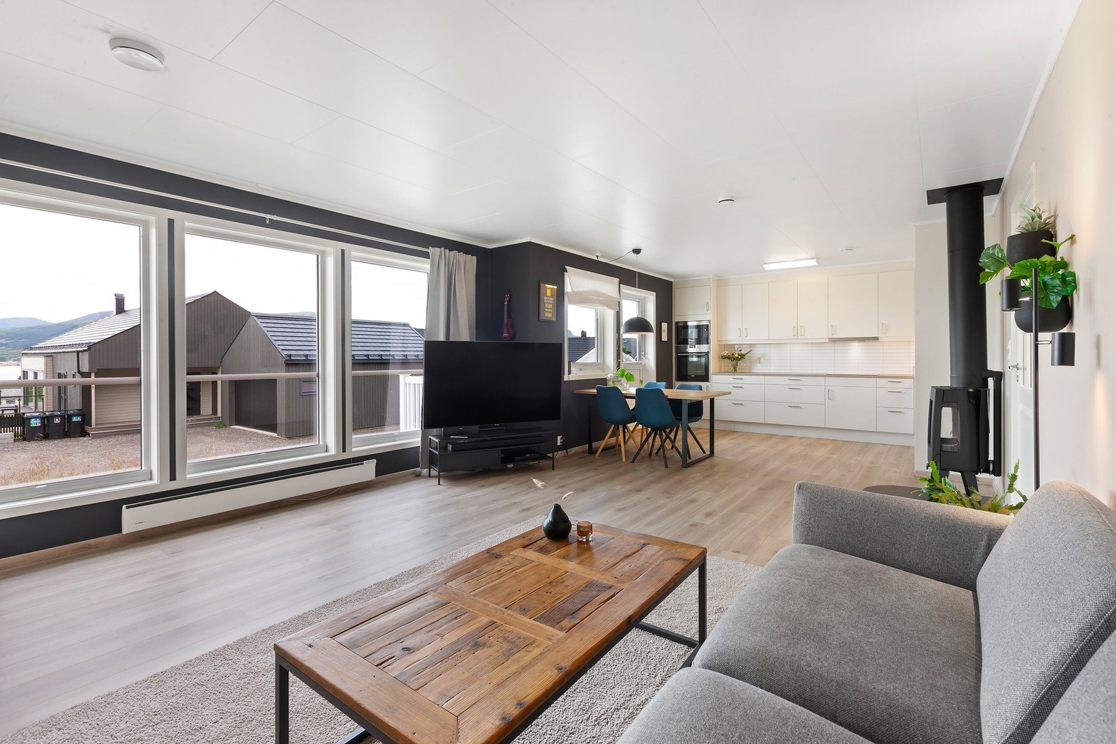 Lys og moderne stue med store vinduer, fine fargevalg og god plass til sofagruppe Galleribilde