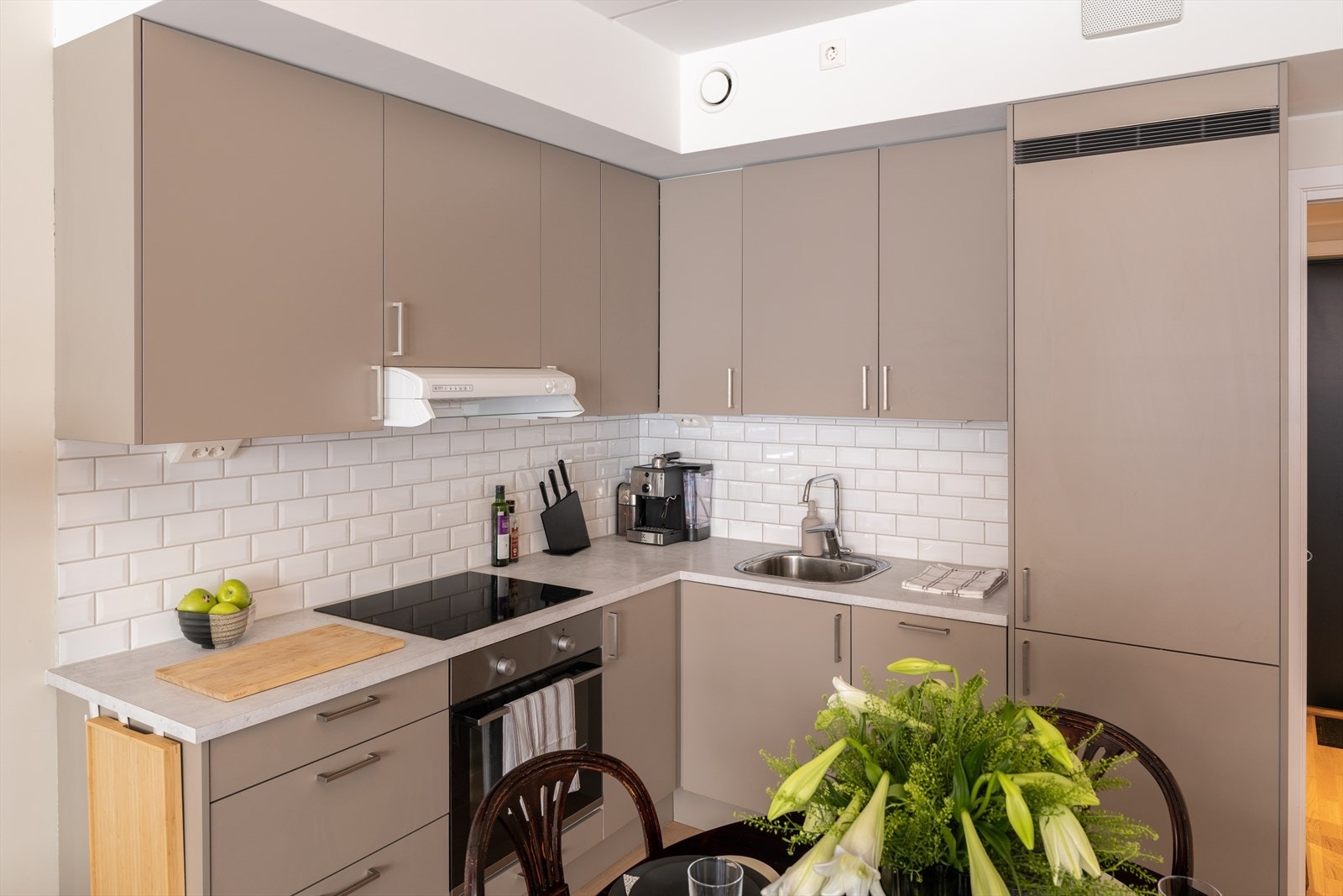 Kjøkkenet har integrerte hvitevarer som stekeovn, platetopp, oppvaskmaskin og kjøleskap med fryser. Galleribilde