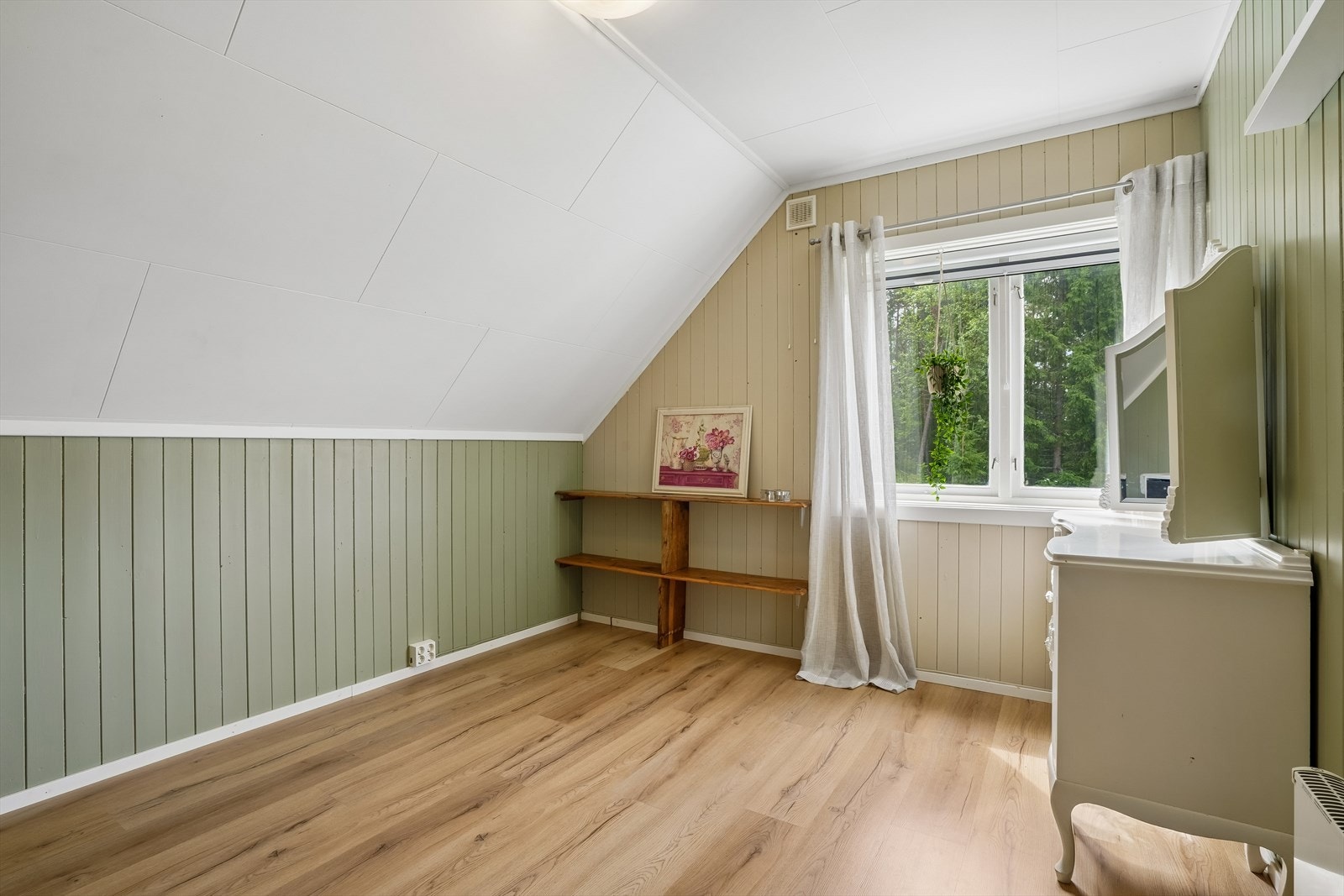 Et av tre soverom i andre etasje, med laminatgulv og panel på veggene. Galleribilde