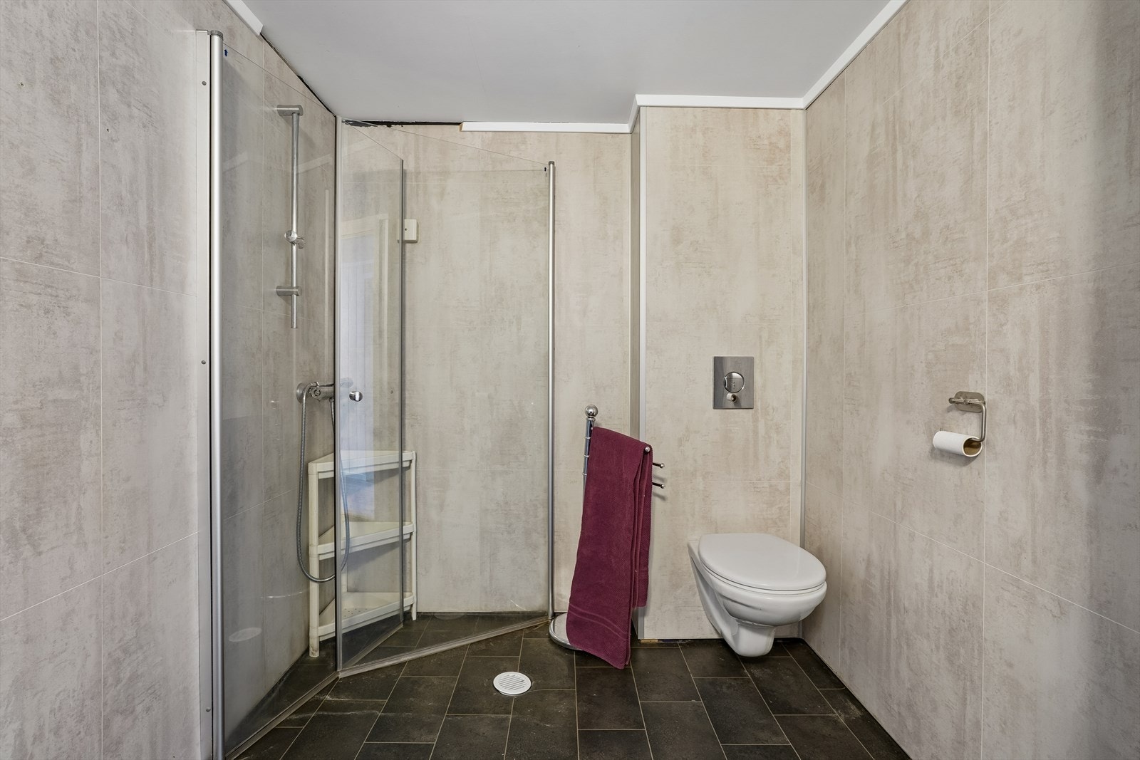 Badet har dusjhjørne med svingdører og vegghengt toalett. Galleribilde