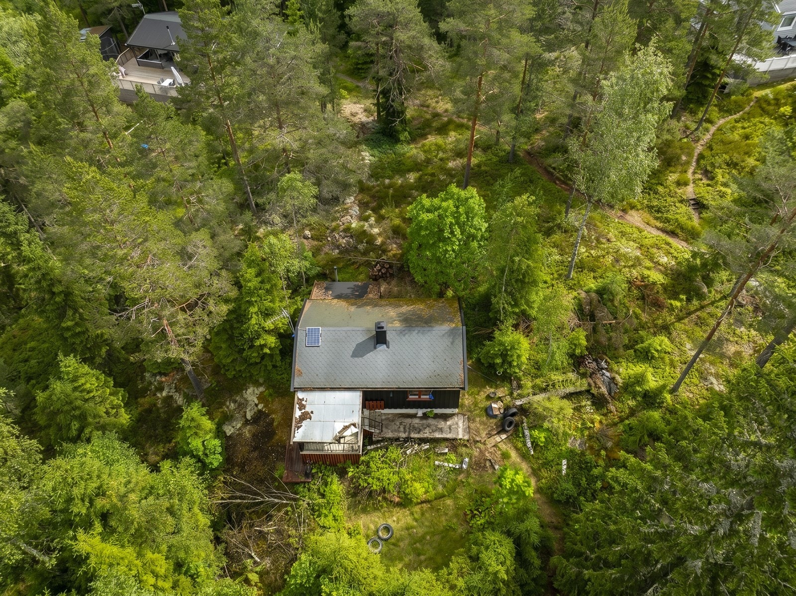 Hytta er omgitt av skog og natur, med byggegrunn av fjell. Galleribilde