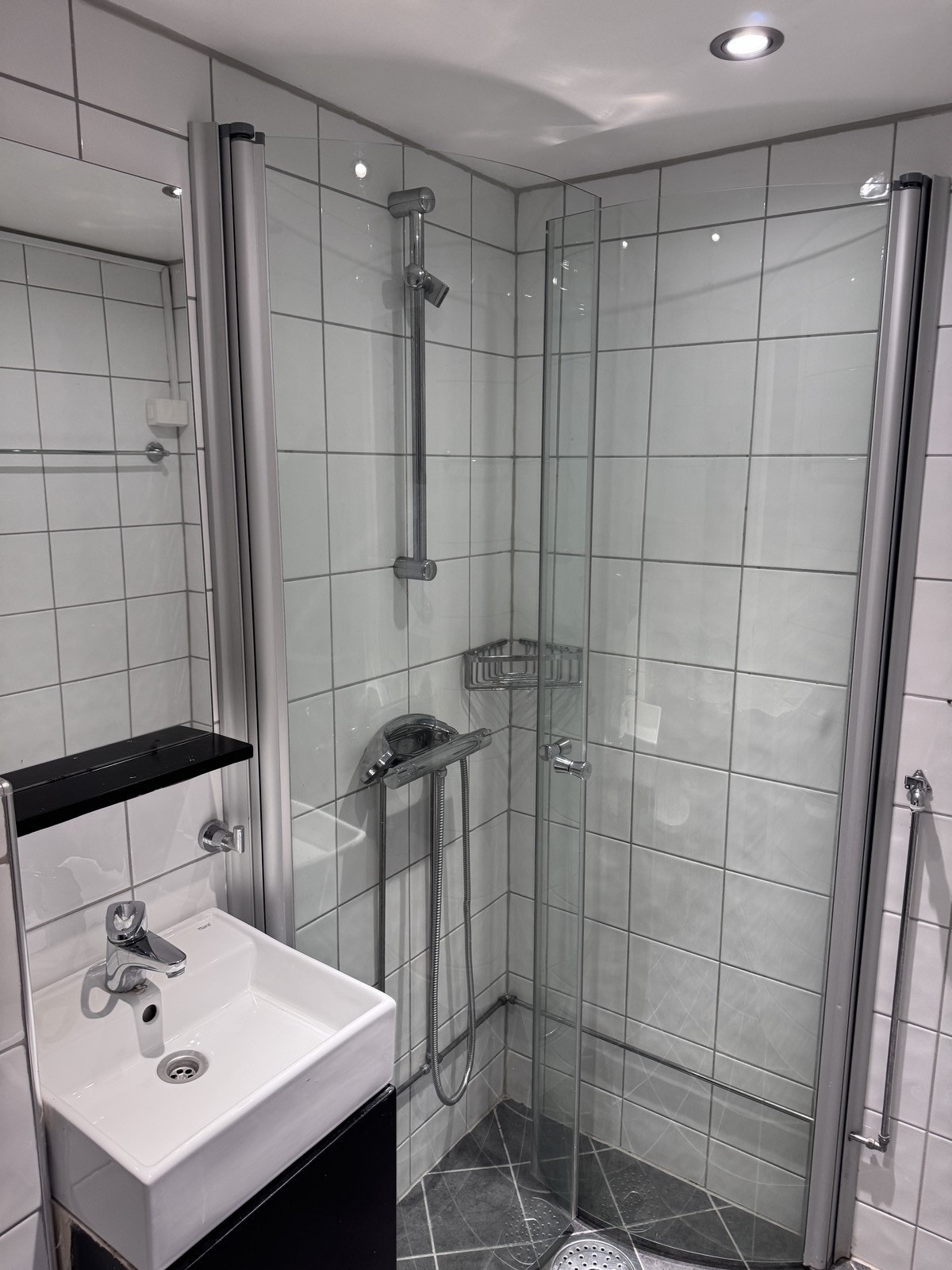 Flislagt bad med downlights i tak og opplegg for vaskemaskin. Galleribilde