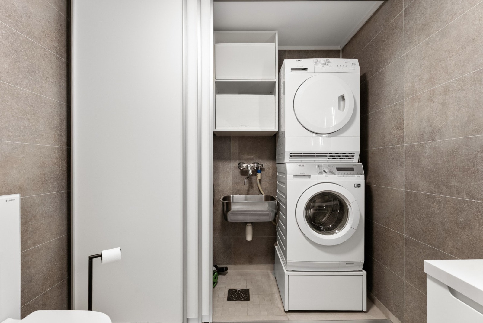 Praktisk vaskeromsnisje med opplegg for vaskesøyle. Galleribilde