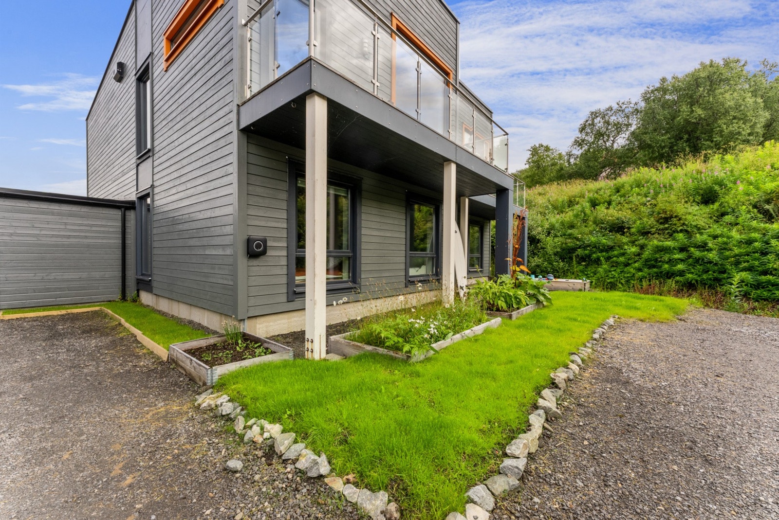 Pent opparbeidet hageflekk med flott beplantning. Legg merke til el-bil lader. Galleribilde