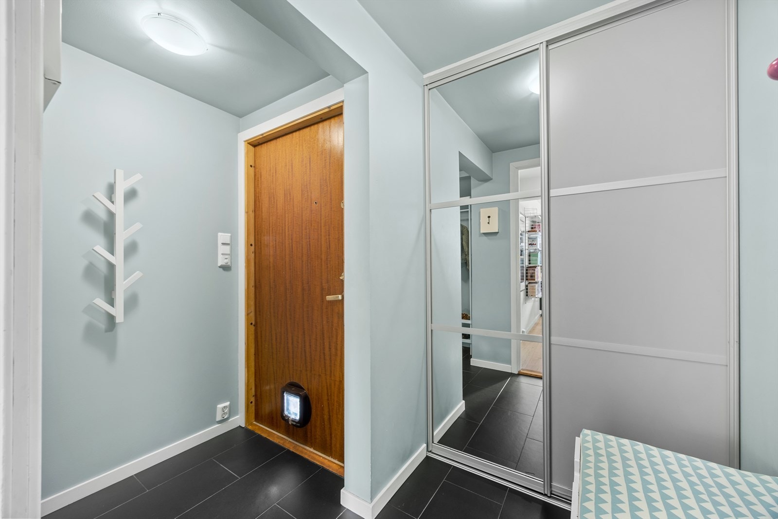 Velkommen inn i en trivelig entré med god plass til oppbevaring av yttertøy og sko i en praktisk skyvedørsgarderobe. Galleribilde