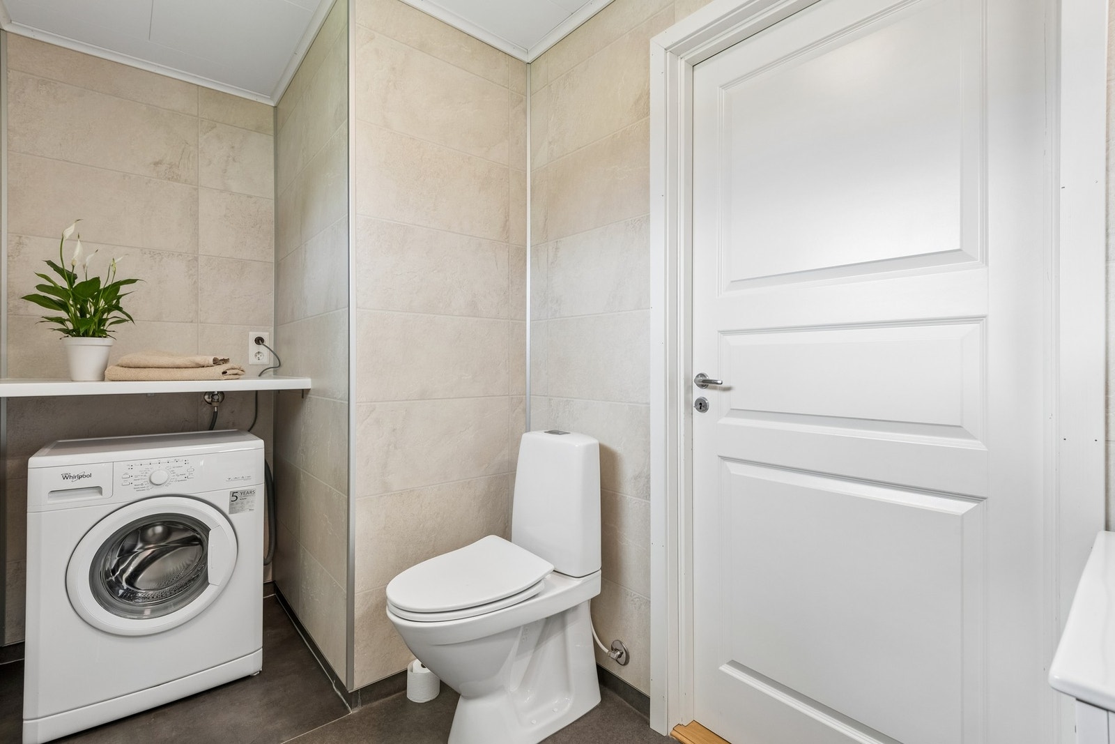 Badet er kombinert med vaskerom og har opplegg for vaskemaskin med en praktisk benkplate over. Galleribilde