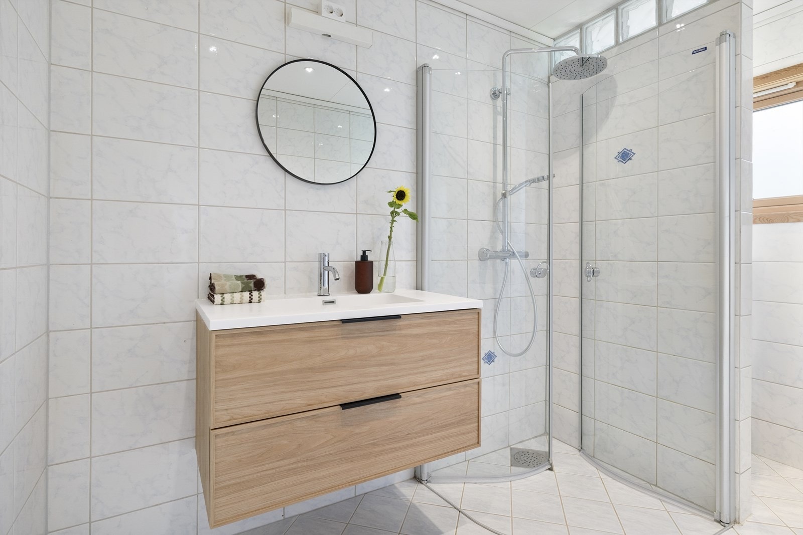 Badet er helfliset og videre innredet med servant i baderomsmøbel og dusjnisje. Det er varmekabler i gulv. Badet er fra 1999. Galleribilde