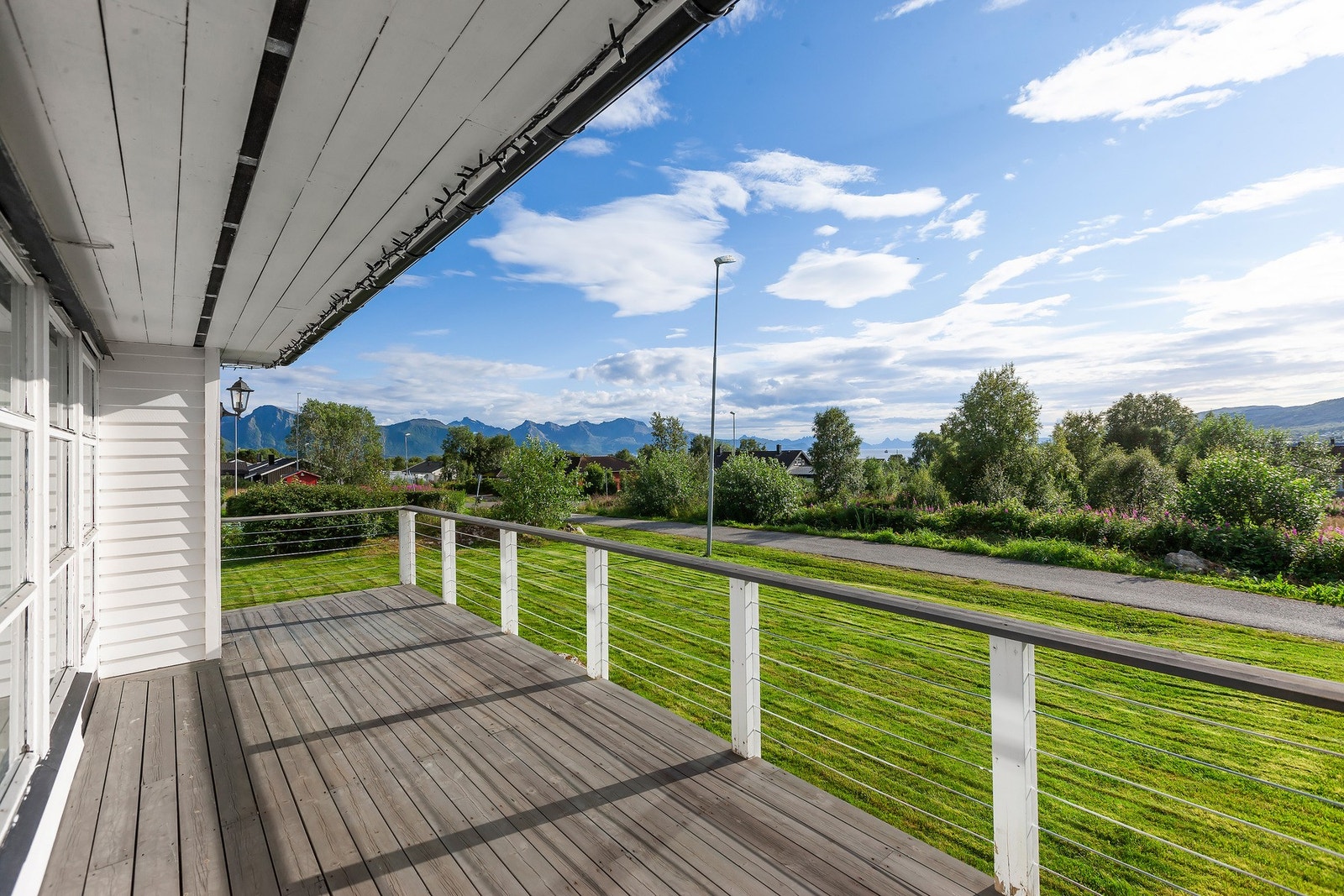 Veranda med utsikt mot grøntområder, sjø og fjell. Galleribilde
