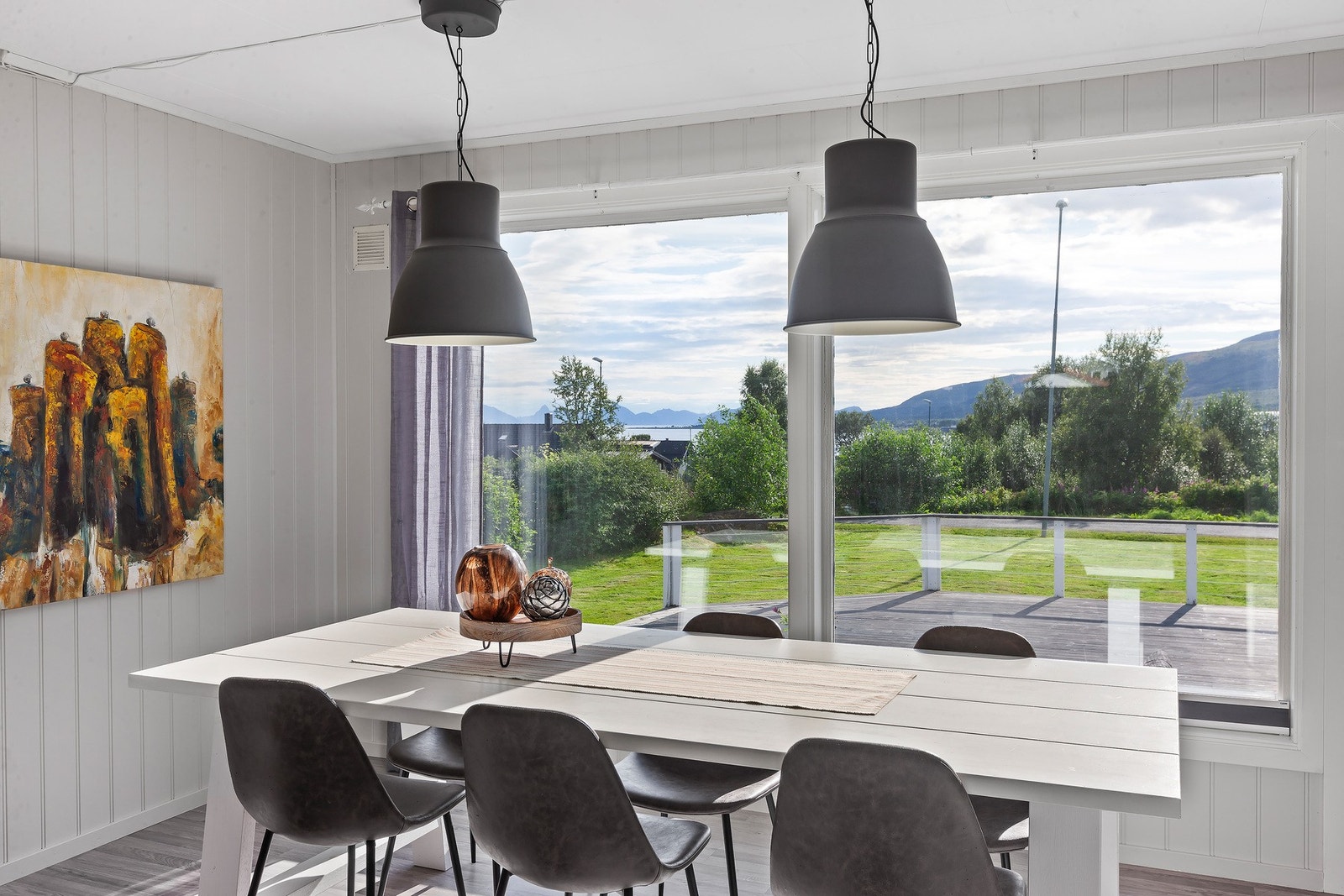 Spisestuen har flott utsikt mot hage, sjø og fjell. Galleribilde