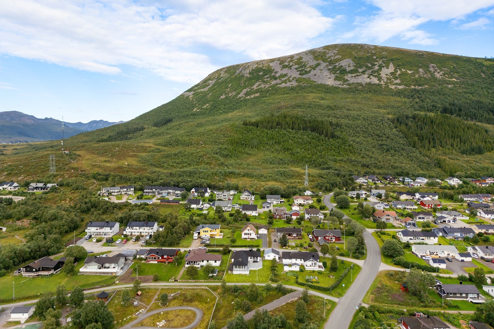 Oversiktsbilde som viser eiendommens nærområde og fjellene i bakkant. Galleribilde