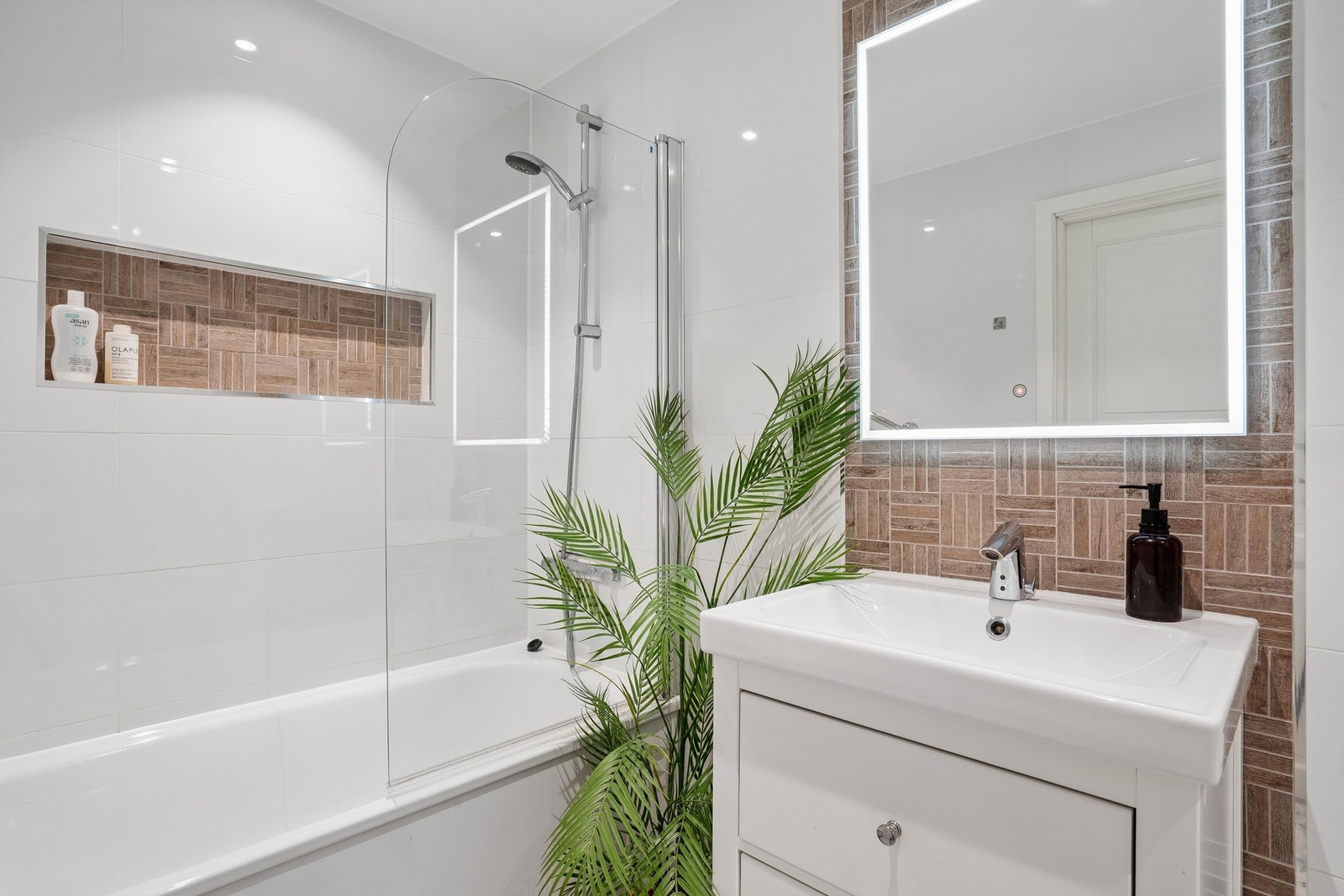 Badet har en stilren innredning med vegghengt toalett, badekar med vegghengt armatur og gulvstående servantinnredning. Material- og utstyrsvalgene bidrar til et moderne og eksklusivt uttrykk. Galleribilde