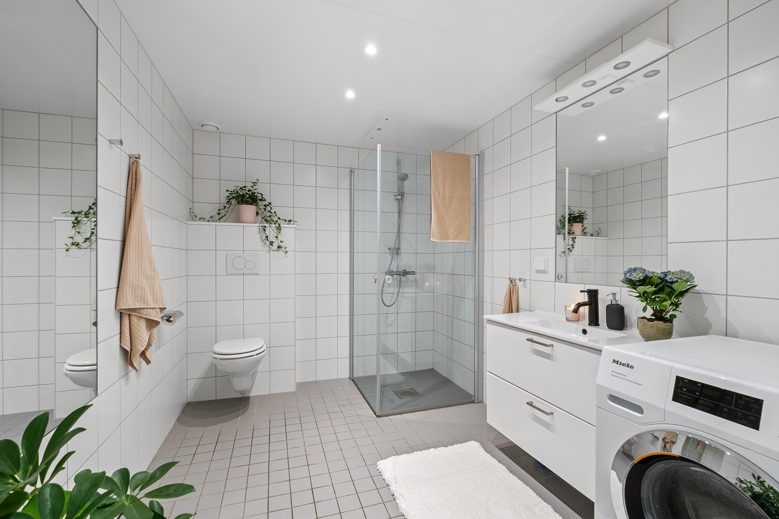 Romslig flislagt bad på 6,4m² med behagelig gulvvarme. Badet fremstår i god stand, og er vurdert til TG1 av takstmann. Galleribilde