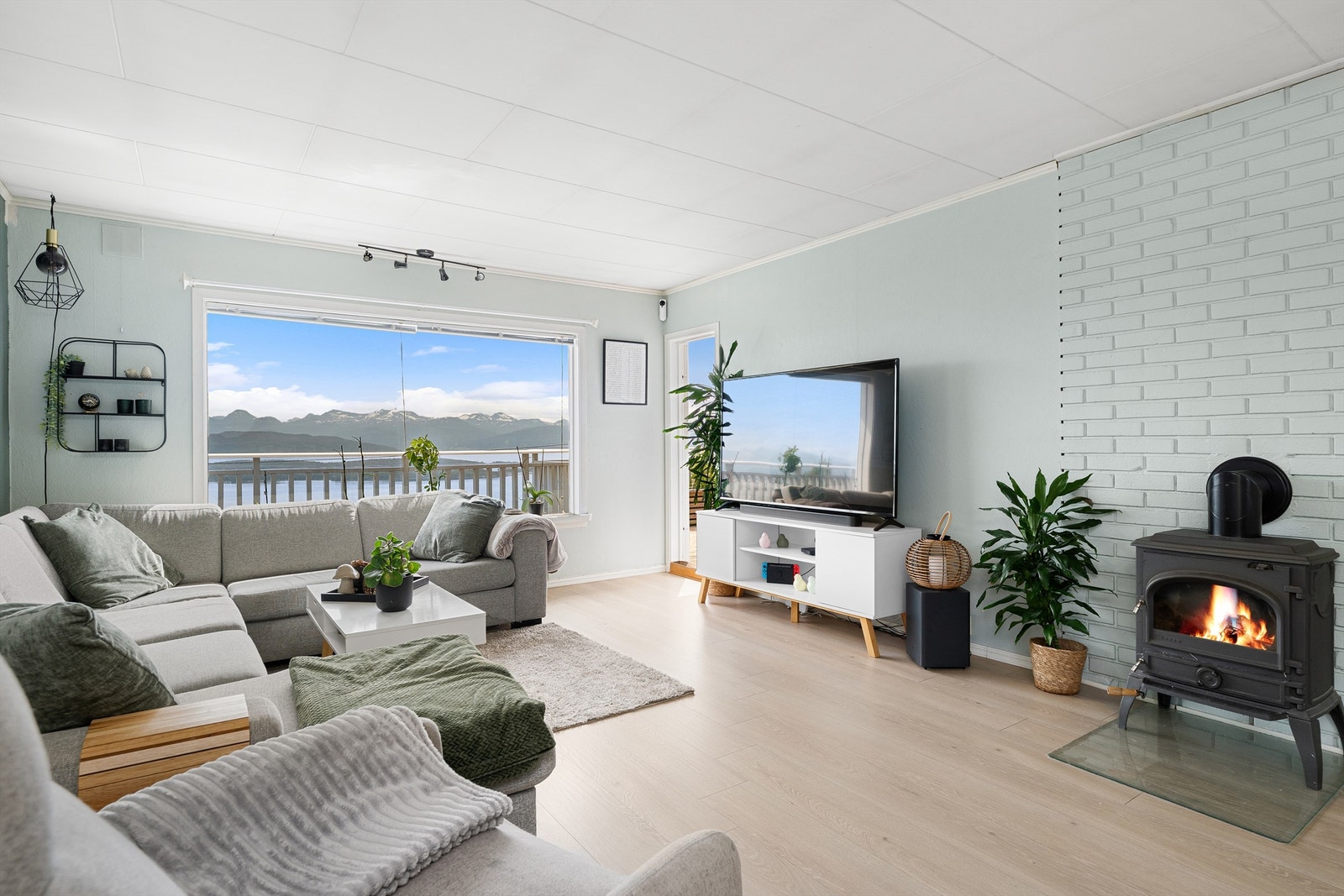 Fra stua er det utgang til veranda. Vedovnen og varmepumpe på stua Galleribilde