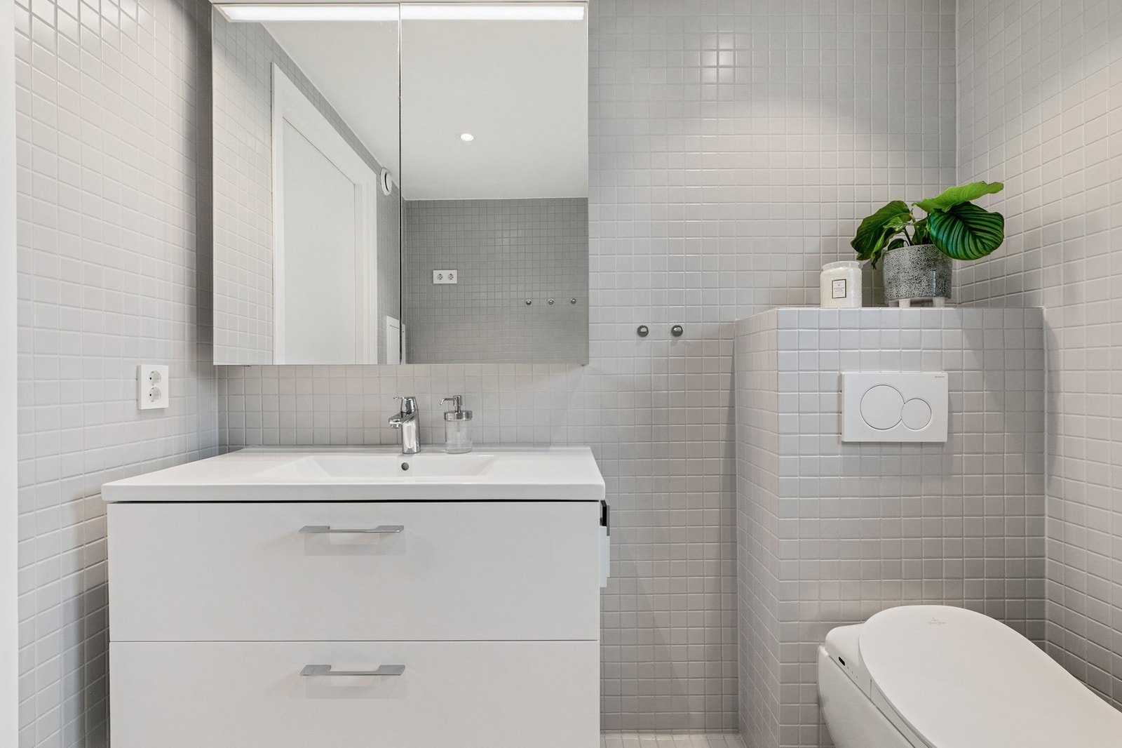Badet er utstyrt med dusjhjørne, dusjtoalett og stilren baderomsinnredning. Galleribilde