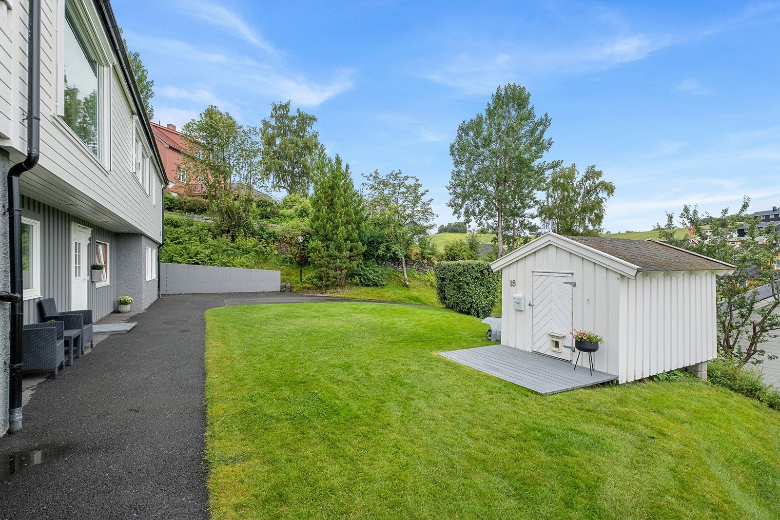 Parkmessig opparbeidet tomt og det er asfaltert rundt deler av huset. I tillegg har boligen en utvendig bod på ca. 20 kvm samt en sjarmerende dukkestue. Galleribilde