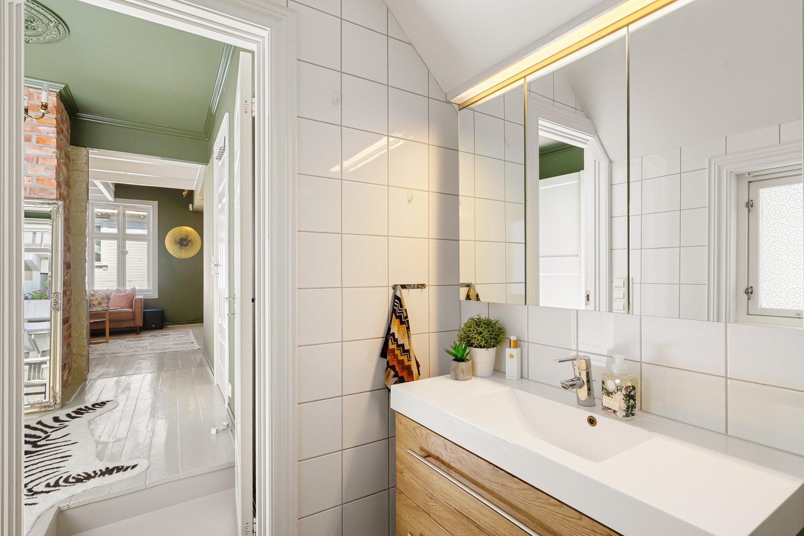 Badet i 2. etasje har vegghengt toalett, hvite veggfliser og sorte gulvfliser med varme. Galleribilde