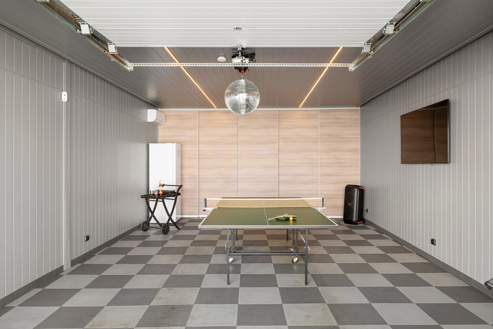 Garasjedelen har innlagt strøm og belysning, og er innredet med gulvbelegg, varmepumpe og gråmalte panelplater. Galleribilde