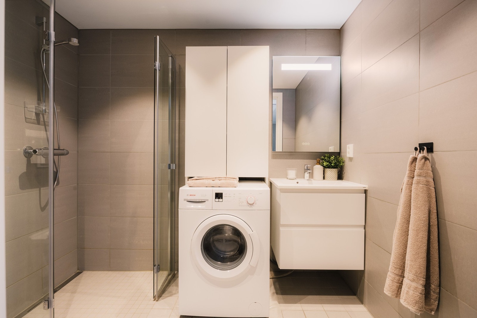 Badet har en moderne utførelse med flislagte gulv og vegger, og et stilrent uttrykk. Galleribilde