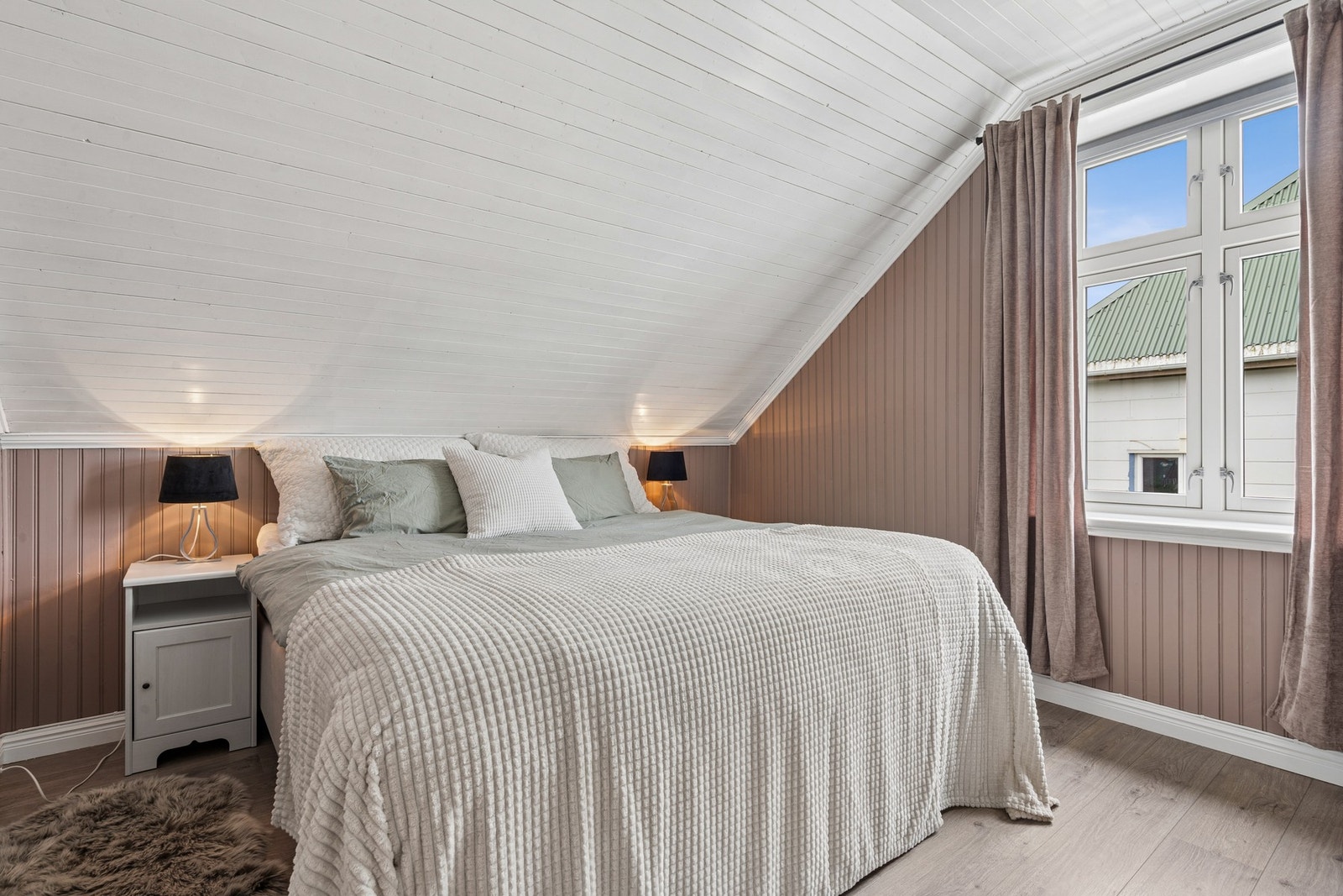 Rommene har vegger med trepanel og malte flater. Galleribilde