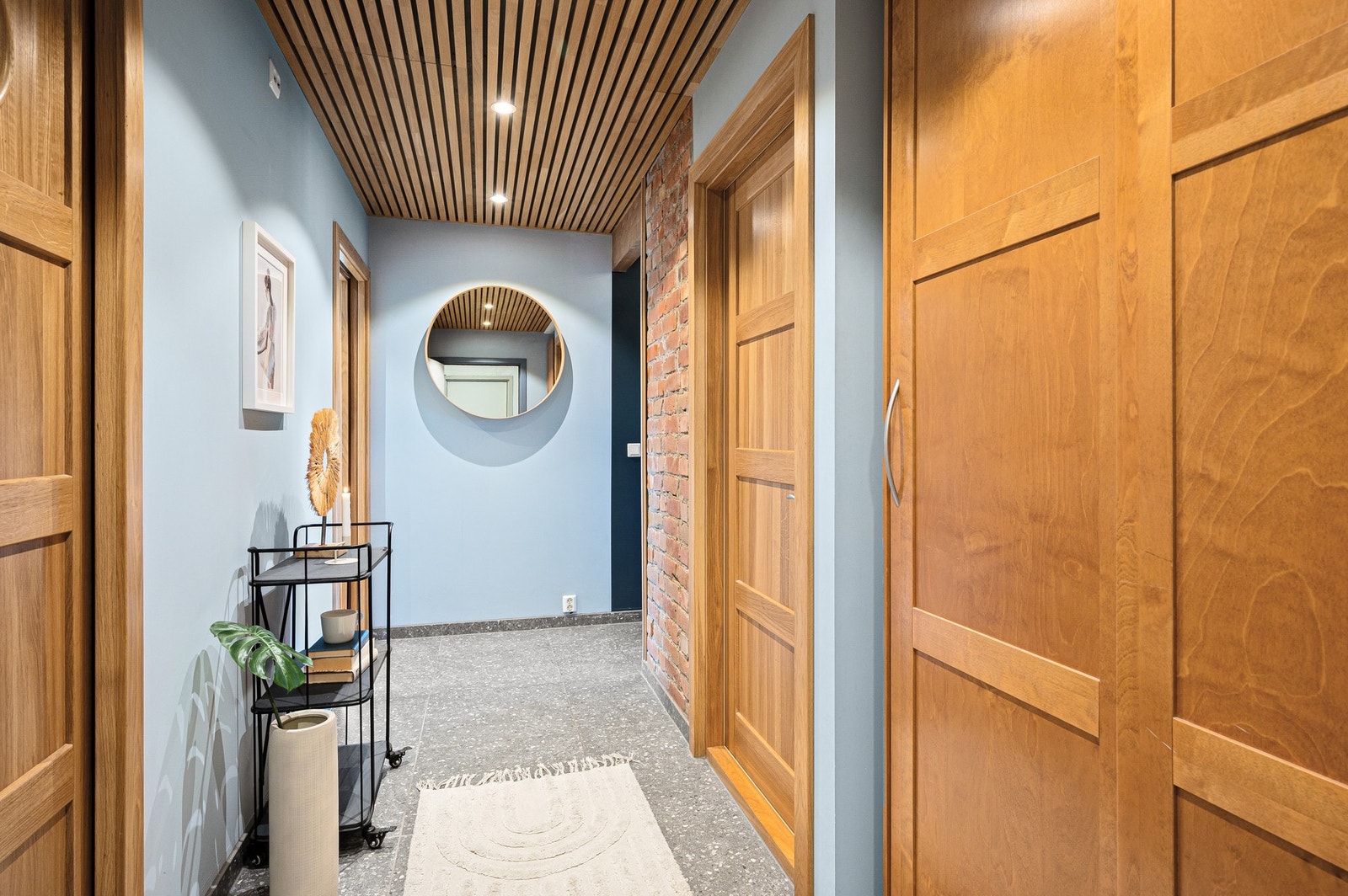 Velkommen inn! I det du kommer inn inngangsdøren har du en skyvedørsgarderobe på din høyre hånd med gode muligheter for oppbevaring av sko og oppheng av yttertøy. Flisene i gangen er "terrazzo", enkelt å renholde. Galleribilde