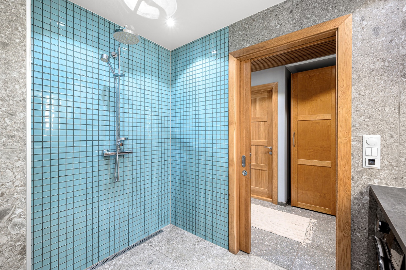 Badet har en unik og åpen dusjløsning kledd med stilfulle fliser som gir badet et særegent preg. Galleribilde