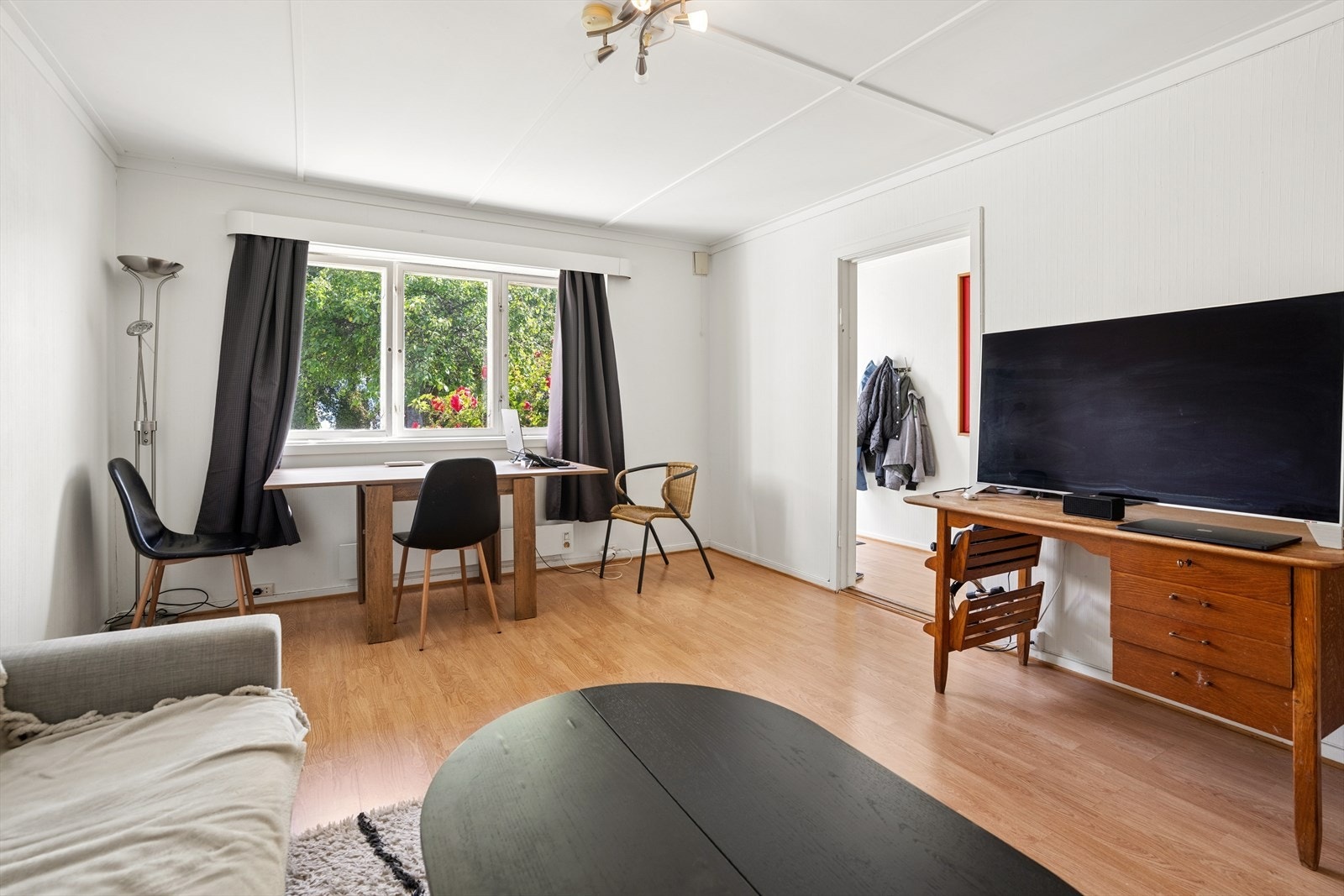 Stuen i sokkelleiligheten har plass til både sittegruppe og en liten arbeidsplass. Galleribilde