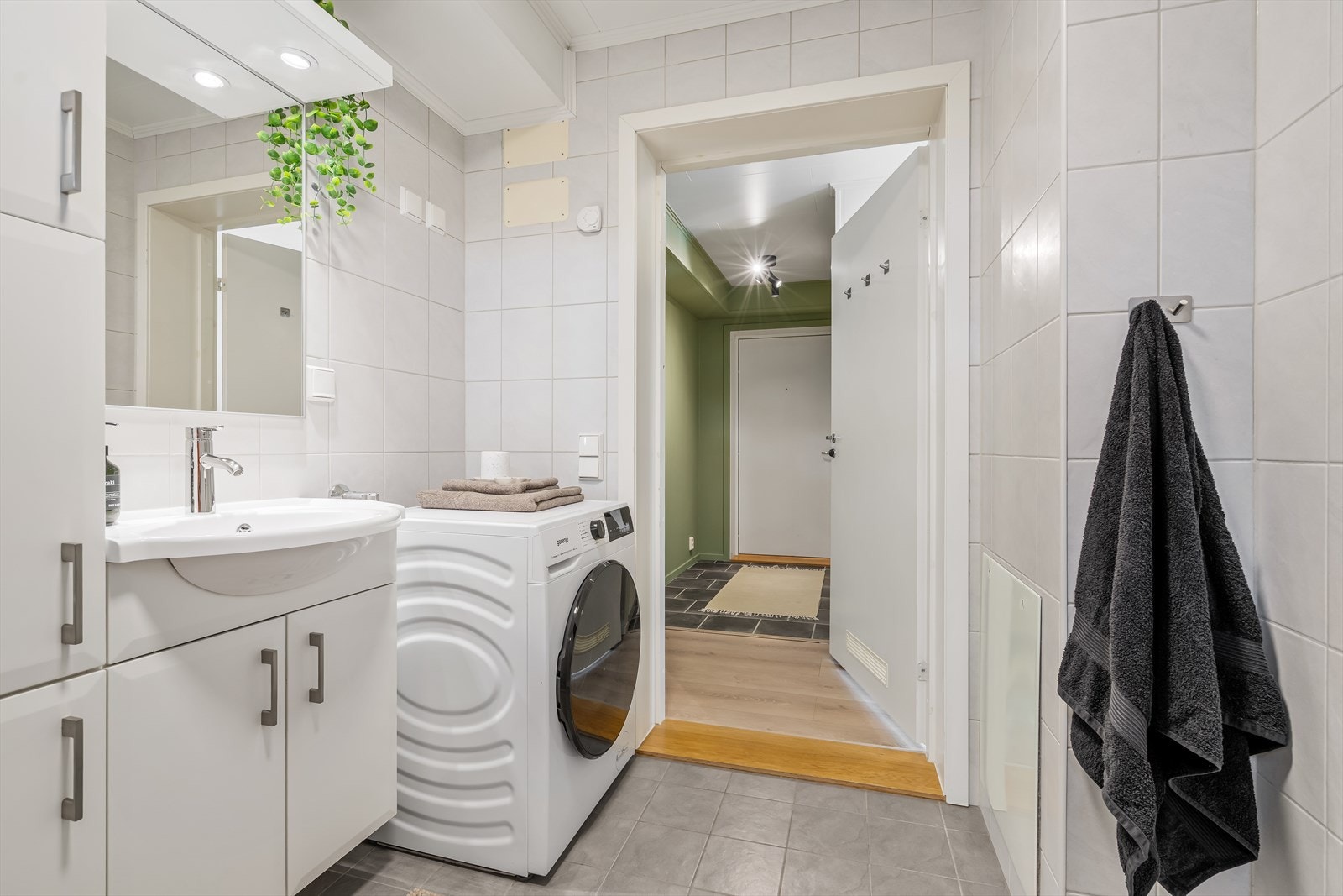Badet har flislagte overflater i nøytrale fargetoner Galleribilde