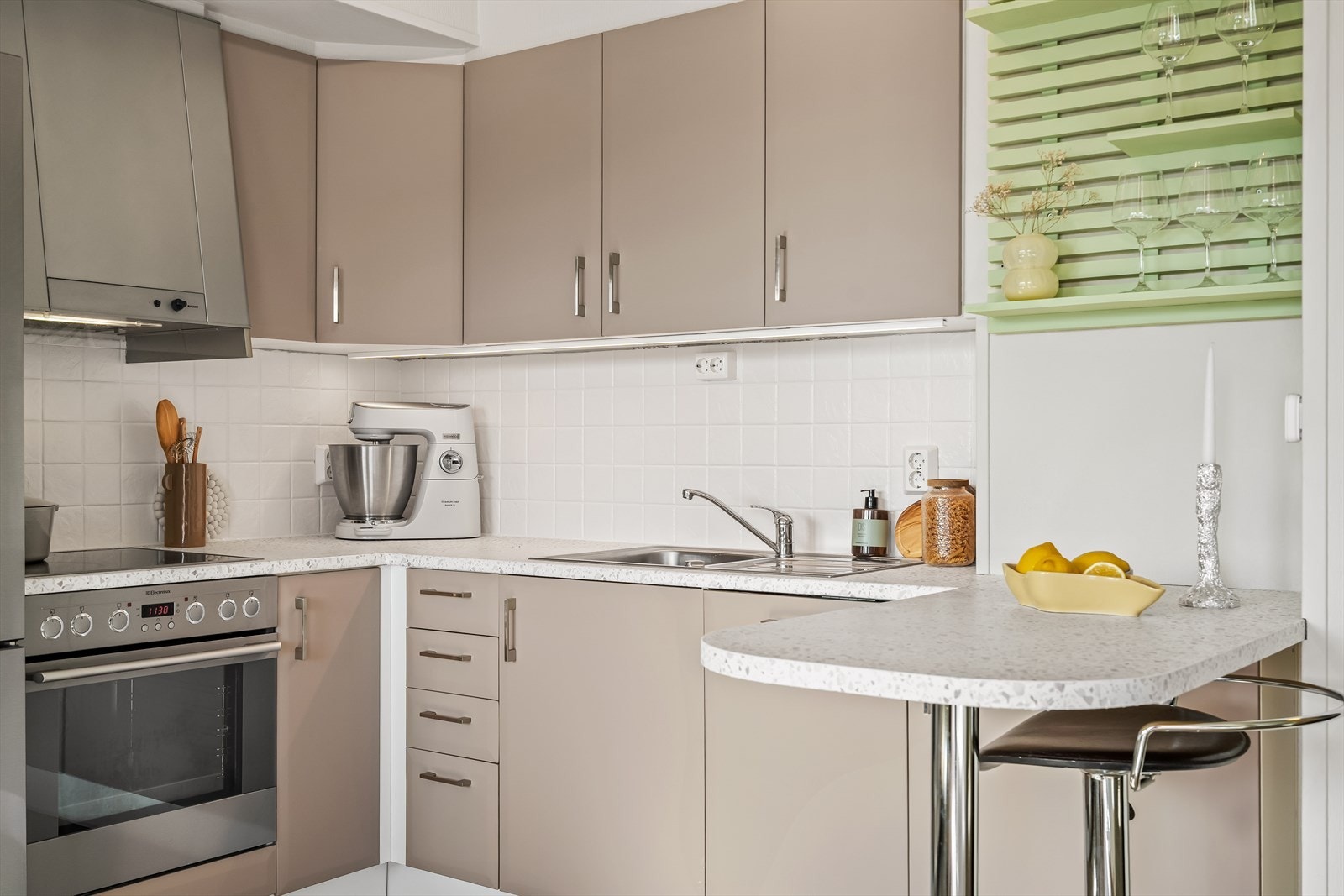 Kjøkkenet har en fin innredning med folierte fronter, laminert benkeplate med nedfelt stålvask og malte fliser på vegg over benk - Det er barløsning med plass til 2/3 barstoler, som også gir økt benkeplass Galleribilde