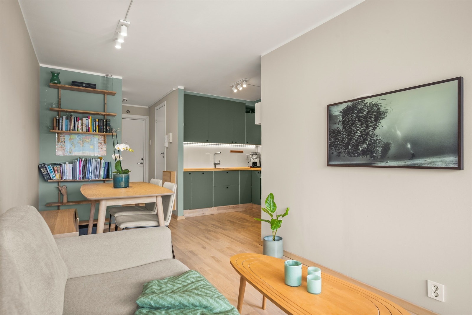 Et stilrent kjøkken i åpen løsning mot stuen skaper en sosial og naturlig atmosfære. Galleribilde