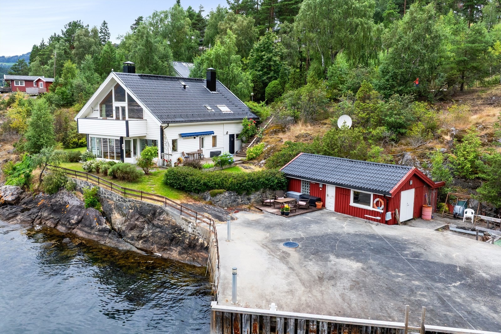Bustaden ligg skjerma og fint tilbaketrekt frå sjøkanten, omgjeven av naturleg vegetasjon og berg. Galleribilde