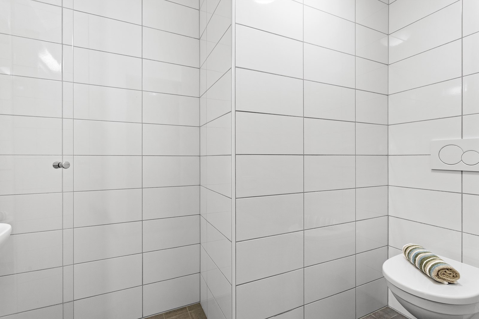 Badet er innreidd med baderomsmøbel med heildekkjande servant, dusjplass og vegghengt toalett. Galleribilde
