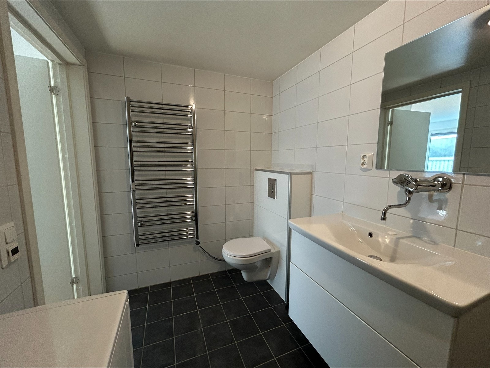 Lekkert og praktisk bad med elegant tørkleholder og integrert vaskemaskin – alt du trenger i hverdag Galleribilde
