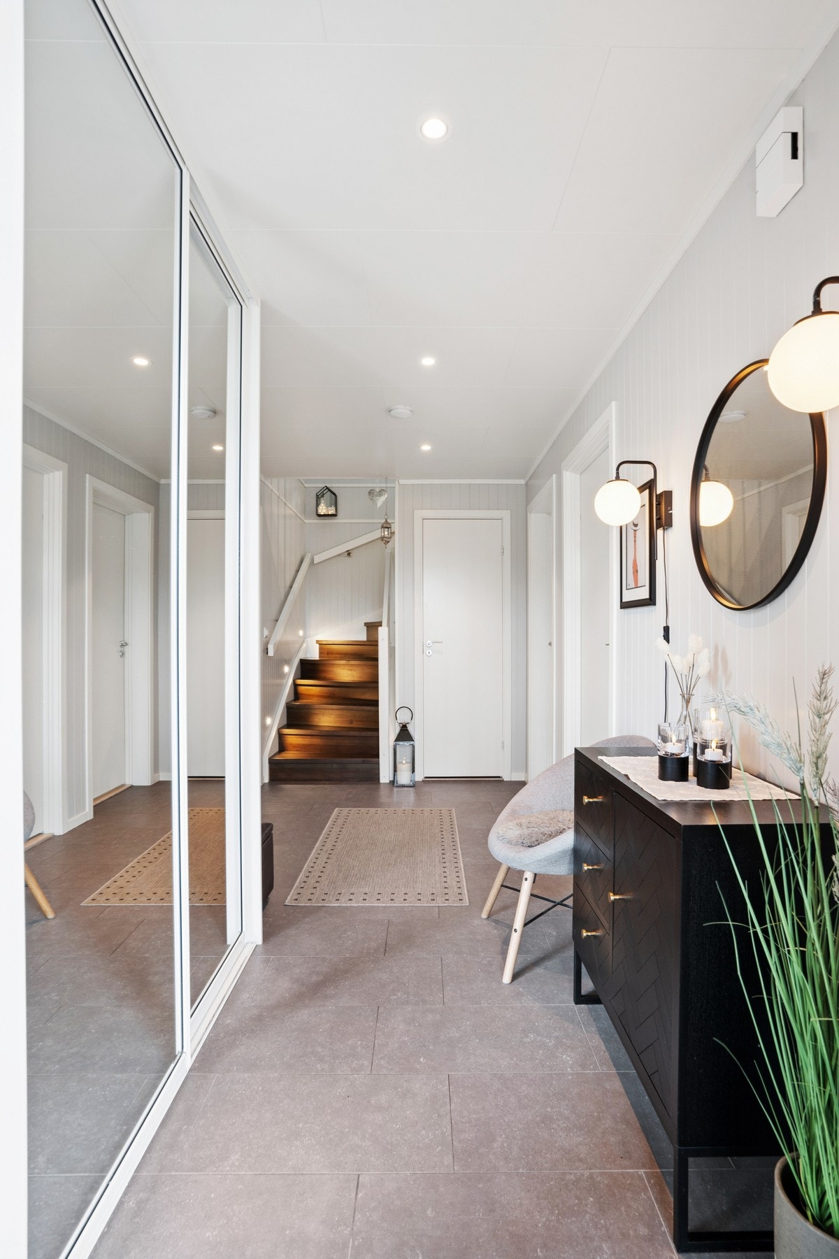 Innbydende entré med stor skyvedørsgarderobe med speilfronter og varme i gulv. Galleribilde