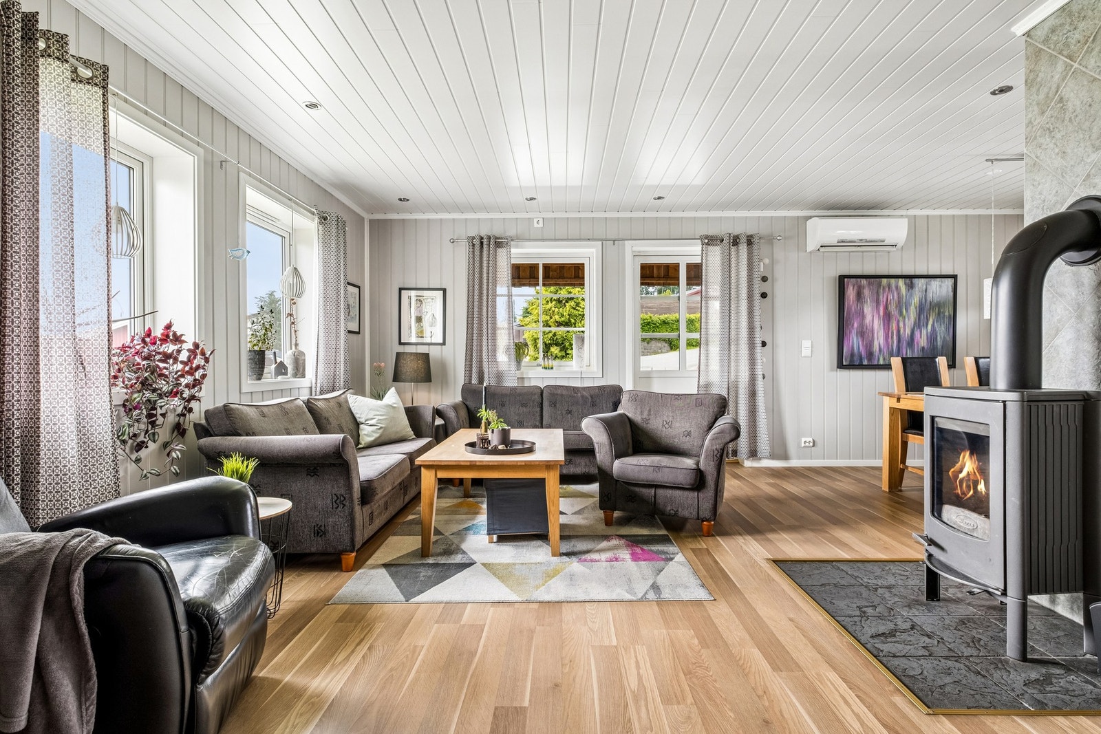 Stuen er lys og innbydende med plater på vegg og laminatgulv. Galleribilde