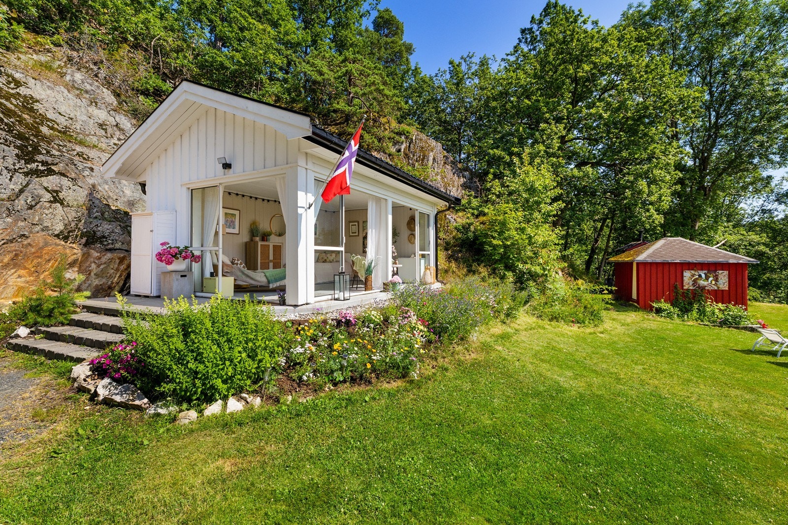 Sommerstua er lyst innredet og inviterer både til den gode hvile og lystig lag med utsikt over hage og fjord. Galleribilde