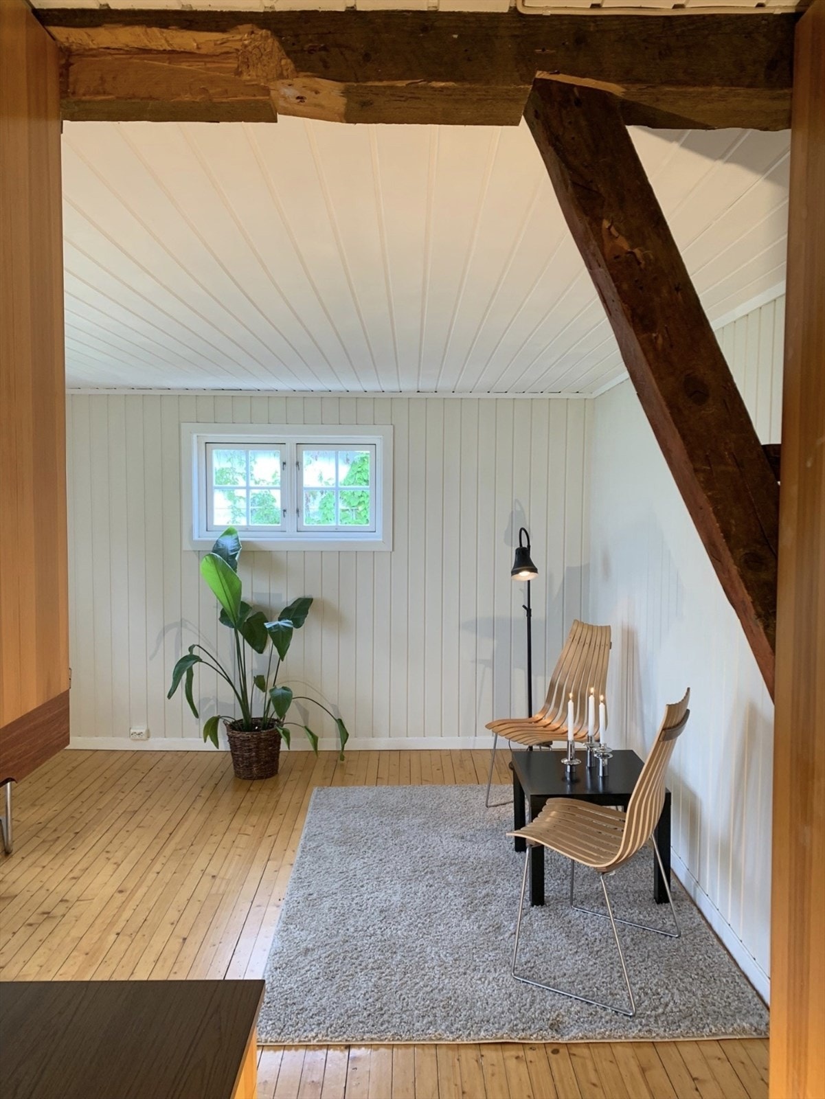 Stuen i eneboligen har synlige, originale trebjelker som gir rommet karakter. Galleribilde