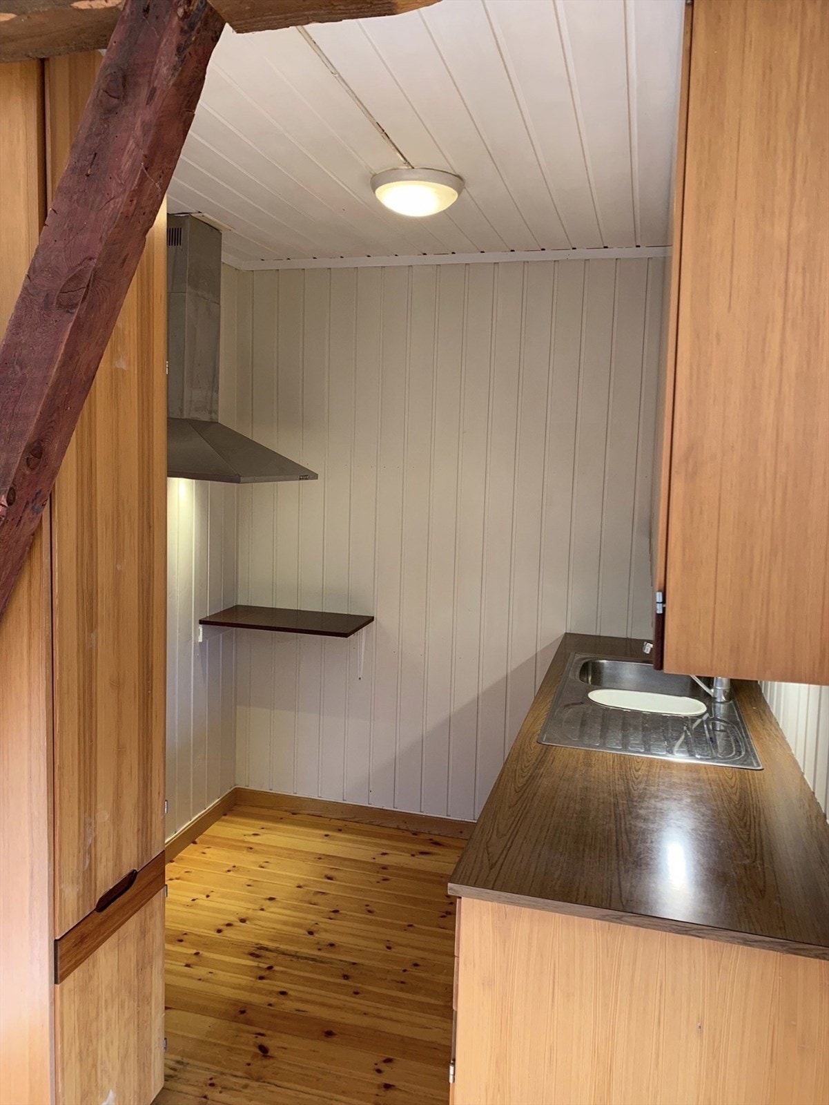 Kjøkken med innredning bestående av glatte fronter og laminatbenkeplate med nedfelt oppvaskkum. Galleribilde
