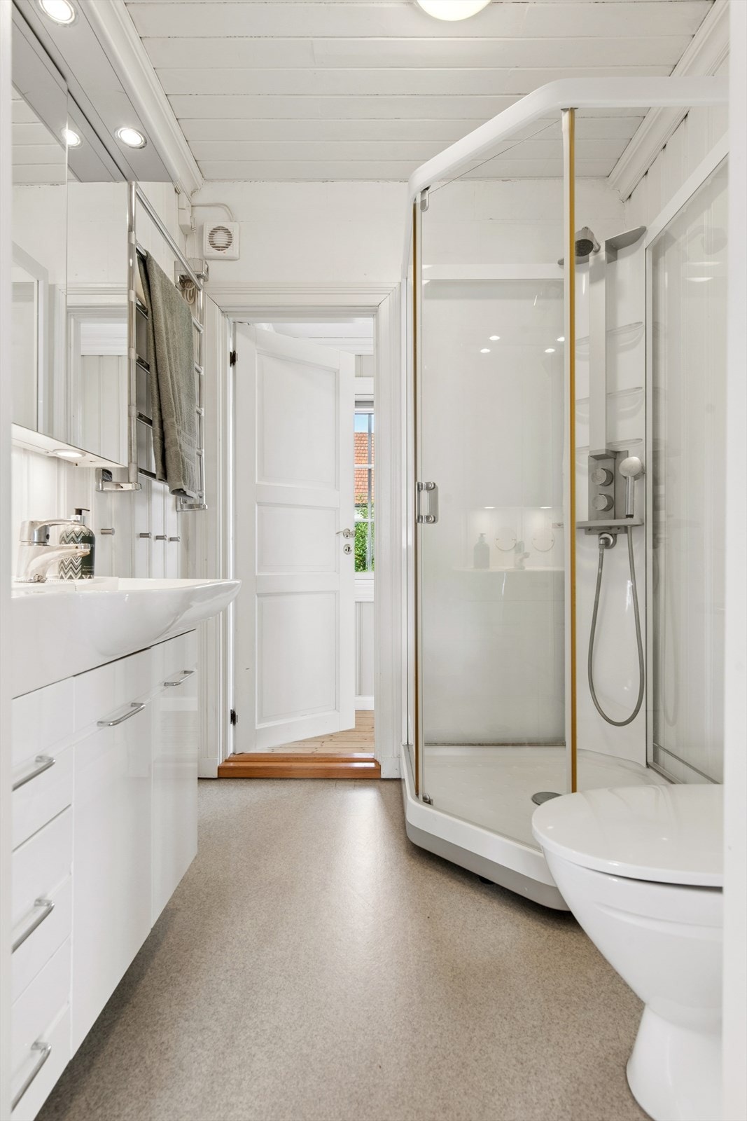 Badet i første etasje ble etablert i 2001 og har vinylbelegg på gulvet samt malte plater og malt panel på veggene. Galleribilde