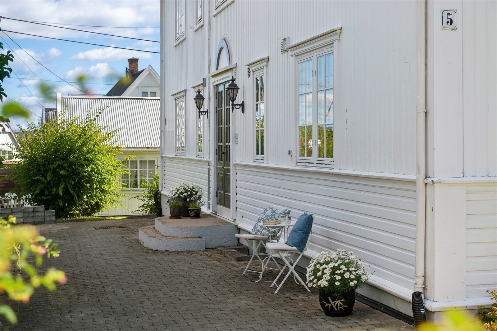 Hyggelig inngangsparti med belegningsstein og en hyggelig sitteplass. Galleribilde