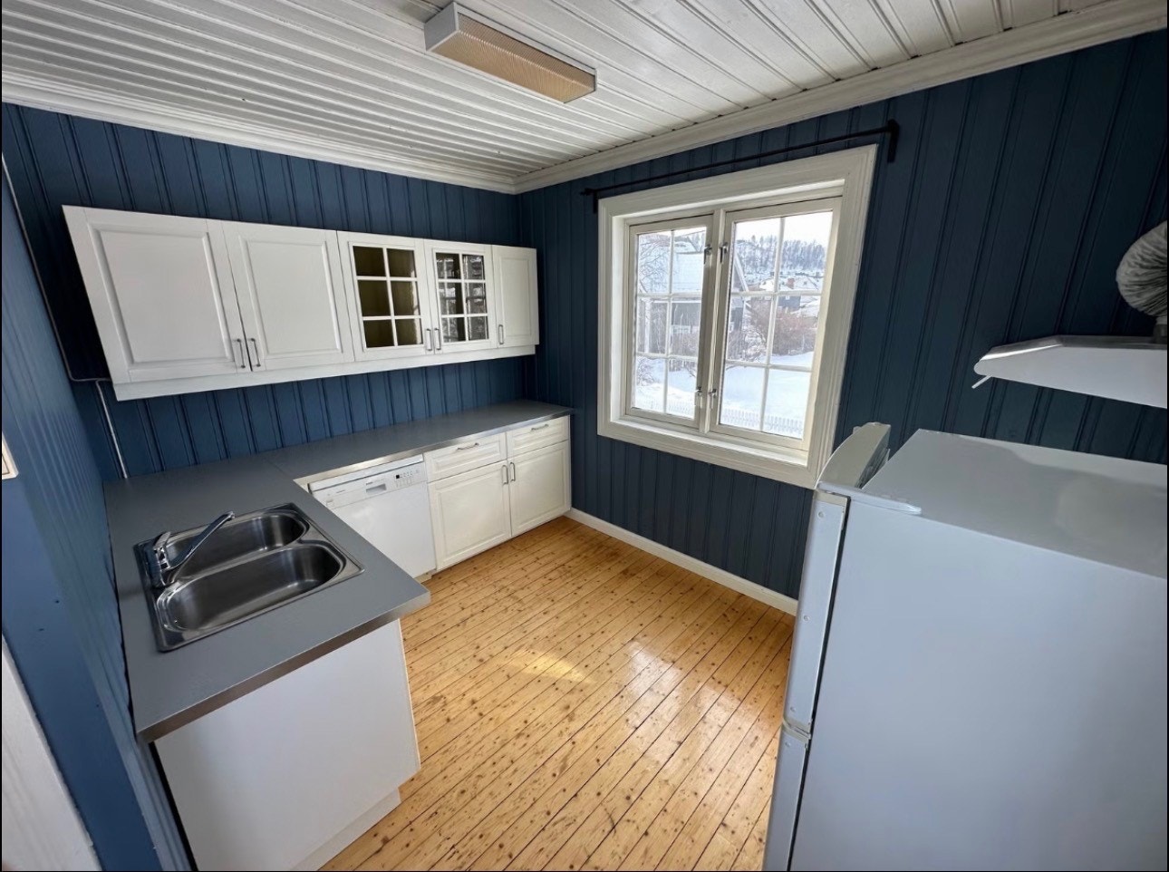 Kjøkkenet har en pen innredning fra 2018 med hvite, profilerte fronter og laminatbenkeplate. Det er godt med skap- og benkeplass, samt plass til spisebord ved vinduet. Galleribilde