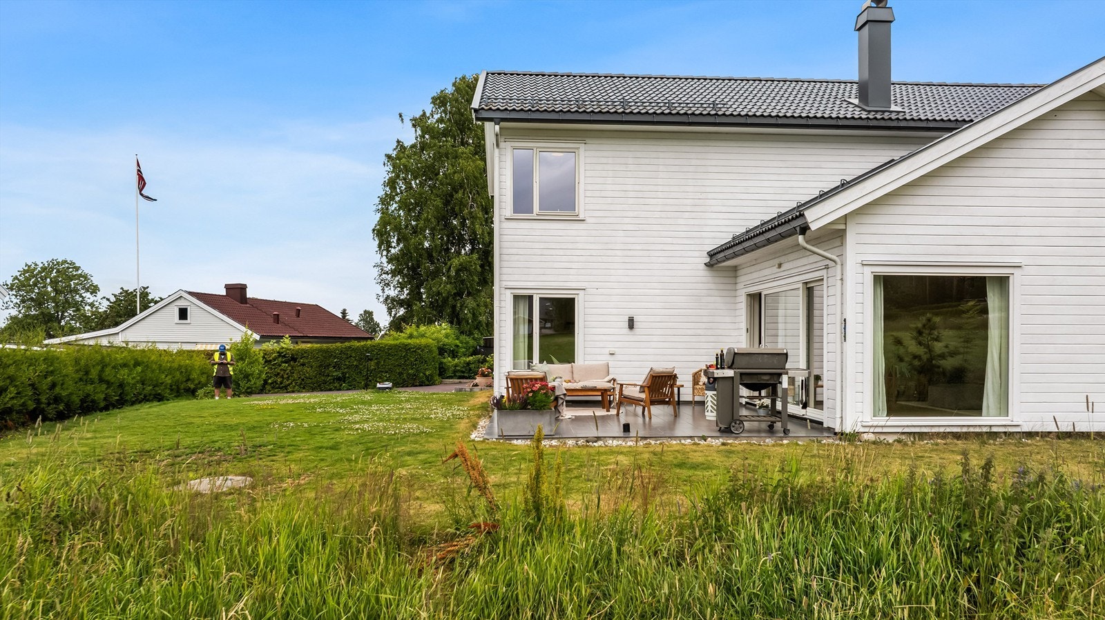 Tomten er opparbeidet med plen og hekk. Galleribilde