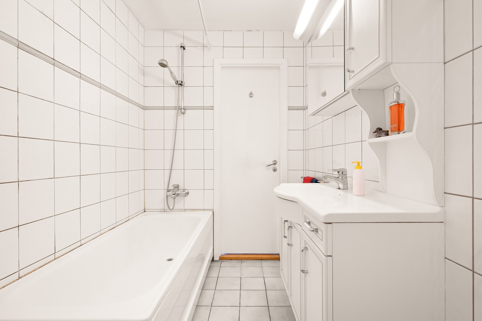 Det er badekar med dusj, toalett og servantinnredning Galleribilde